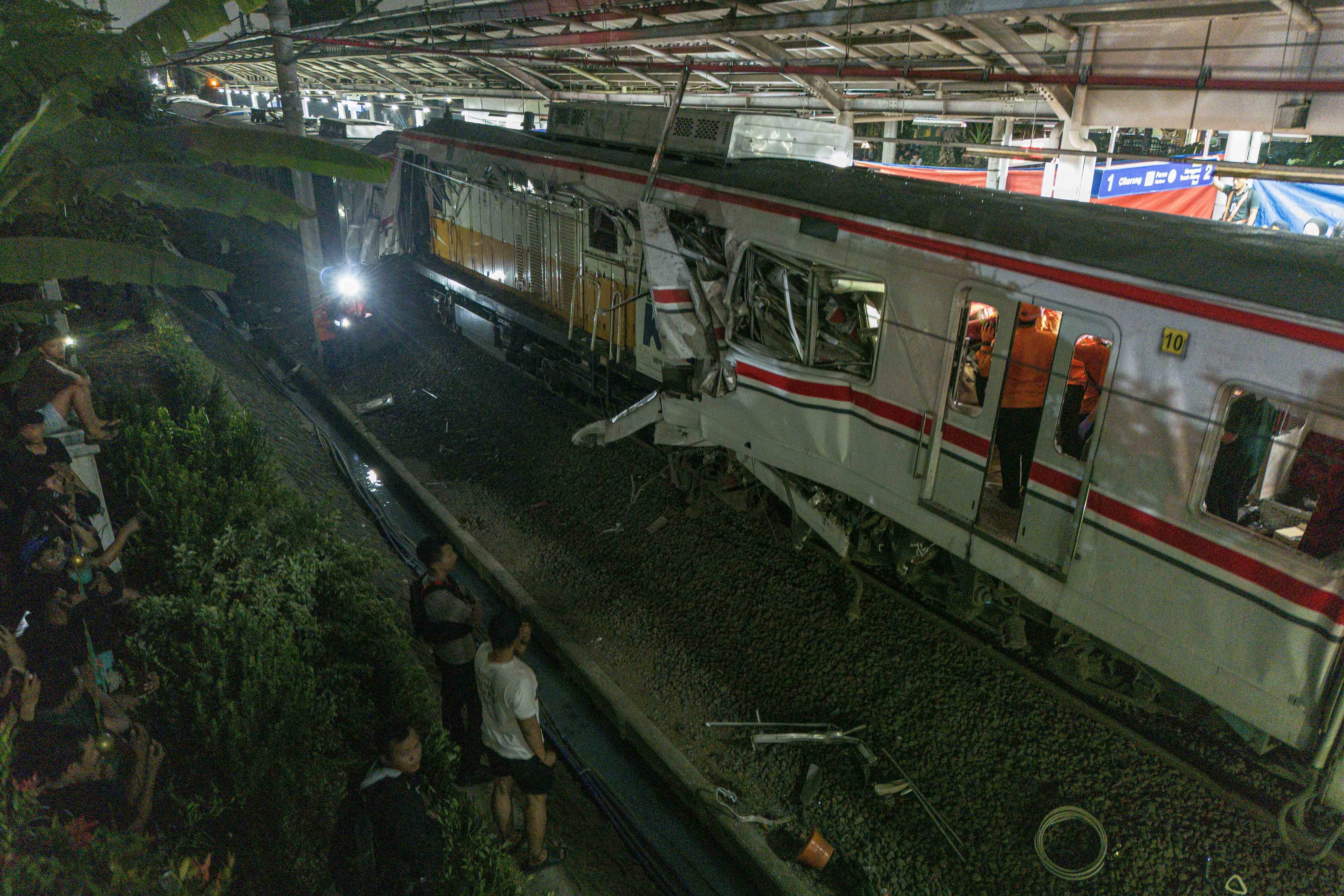 Warga melihat kondisi gerbong KRL Commuterline dan KA Argo Bromo Anggrek relasi Gambir-Surabaya Pasar Turi pascakecelakaan di Stasiun Bekasi Timur, Bekasi, Jawa Barat, Senin (27/4/2026). 