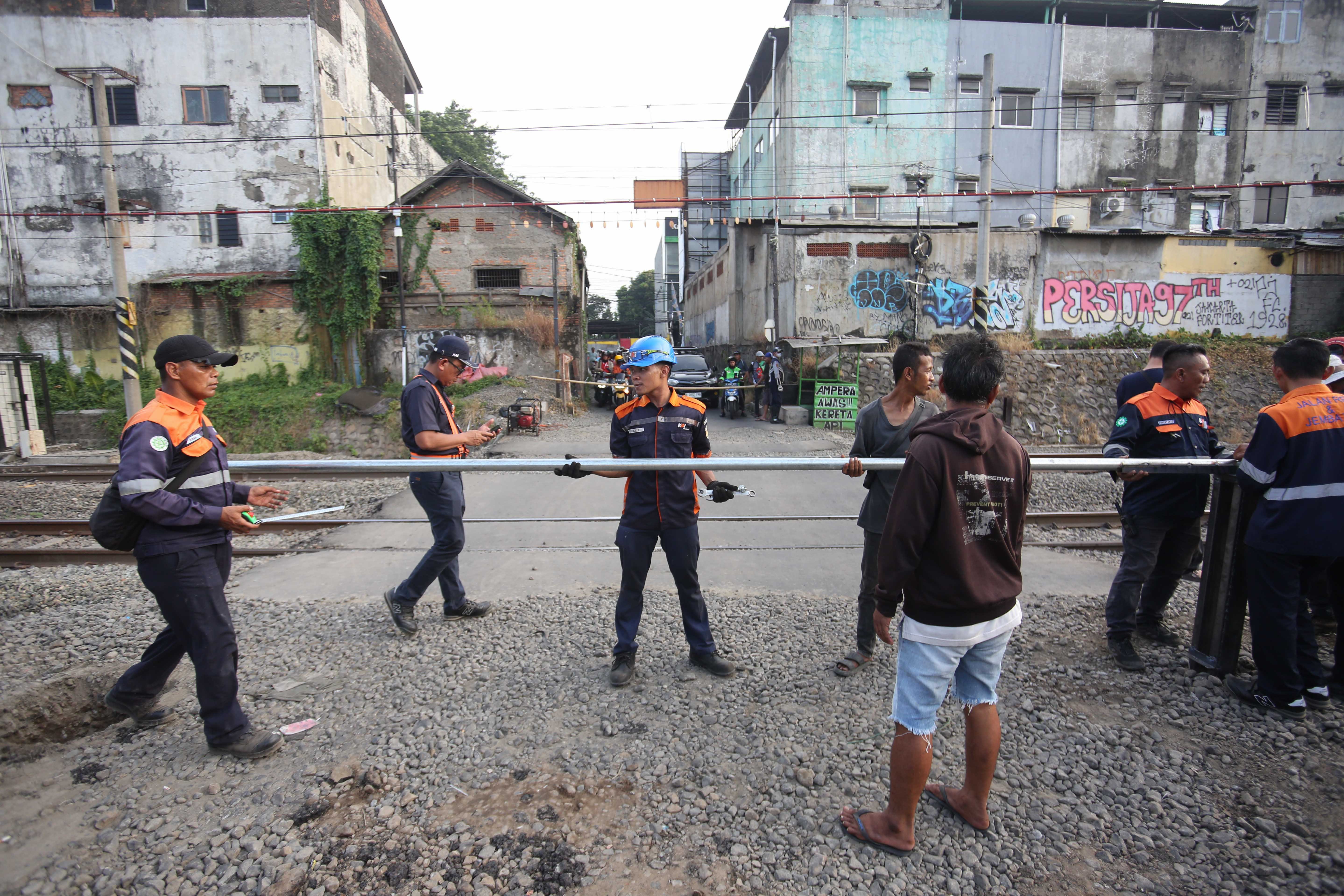 Petugas memasang tiang palang pembatas di perlintasan kereta api sebidang di Jalan Ampera, Kota Bekasi, Jawa Barat, Senin (27/4/2026). PT Kereta Api Indonesia (KAI) Persero menyatakan akan menutup berbagai jalur perlintasan kereta api sebidang yang tidak memenuhi syarat keselamatan menyusul dua tragedi yang melibatkan KRL Commuter Line dengan Taksi Green SM dan KA Argo Bromo Anggrek dengan KRL Commuter Line.