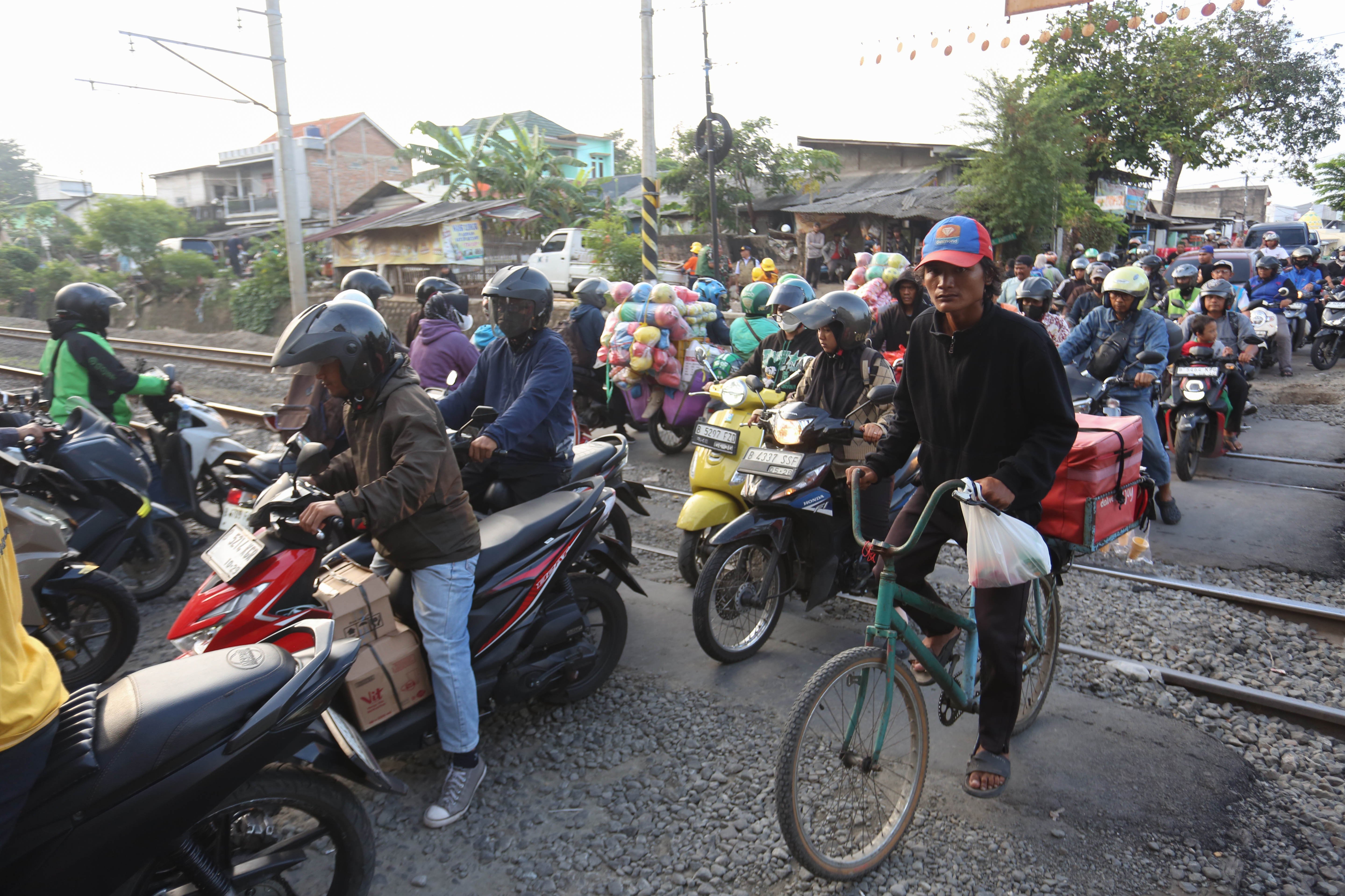 Pengendara melintas di perlintasan kereta api sebidang di Jalan Ampera, Kota Bekasi, Jawa Barat, Senin (27/4/2026). PT Kereta Api Indonesia (KAI) Persero menyatakan akan menutup berbagai jalur perlintasan kereta api sebidang yang tidak memenuhi syarat keselamatan menyusul dua tragedi yang melibatkan KRL Commuter Line dengan Taksi Green SM dan KA Argo Bromo Anggrek dengan KRL Commuter Line.