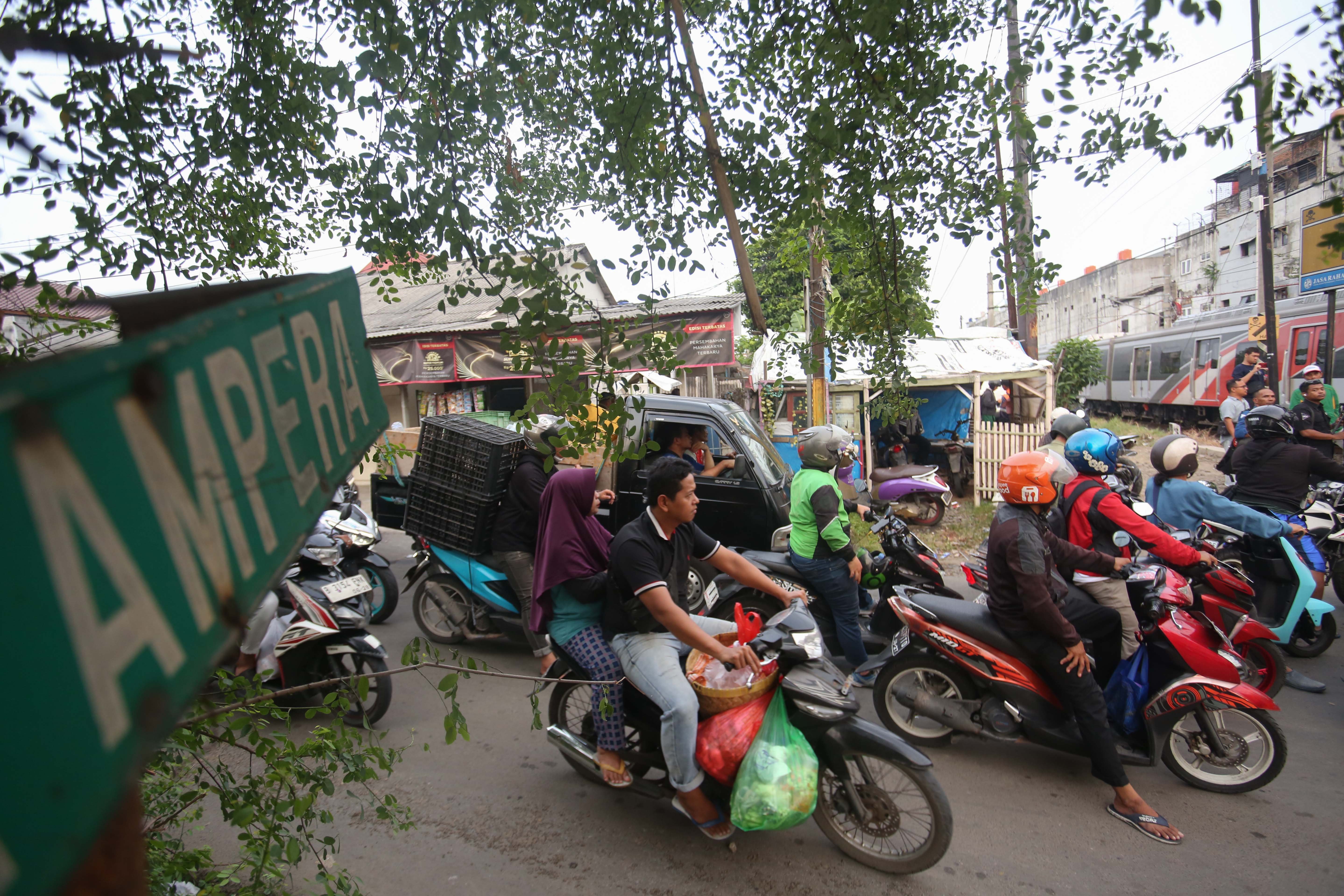 Pengendara menunggu KRL Commuter Line melintas di perlintasan sebidang di Jalan Ampera, Kota Bekasi, Jawa Barat, Senin (27/4/2026). PT Kereta Api Indonesia (KAI) Persero menyatakan akan menutup berbagai jalur perlintasan kereta api sebidang yang tidak memenuhi syarat keselamatan menyusul dua tragedi yang melibatkan KRL Commuter Line dengan Taksi Green SM dan KA Argo Bromo Anggrek dengan KRL Commuter Line.