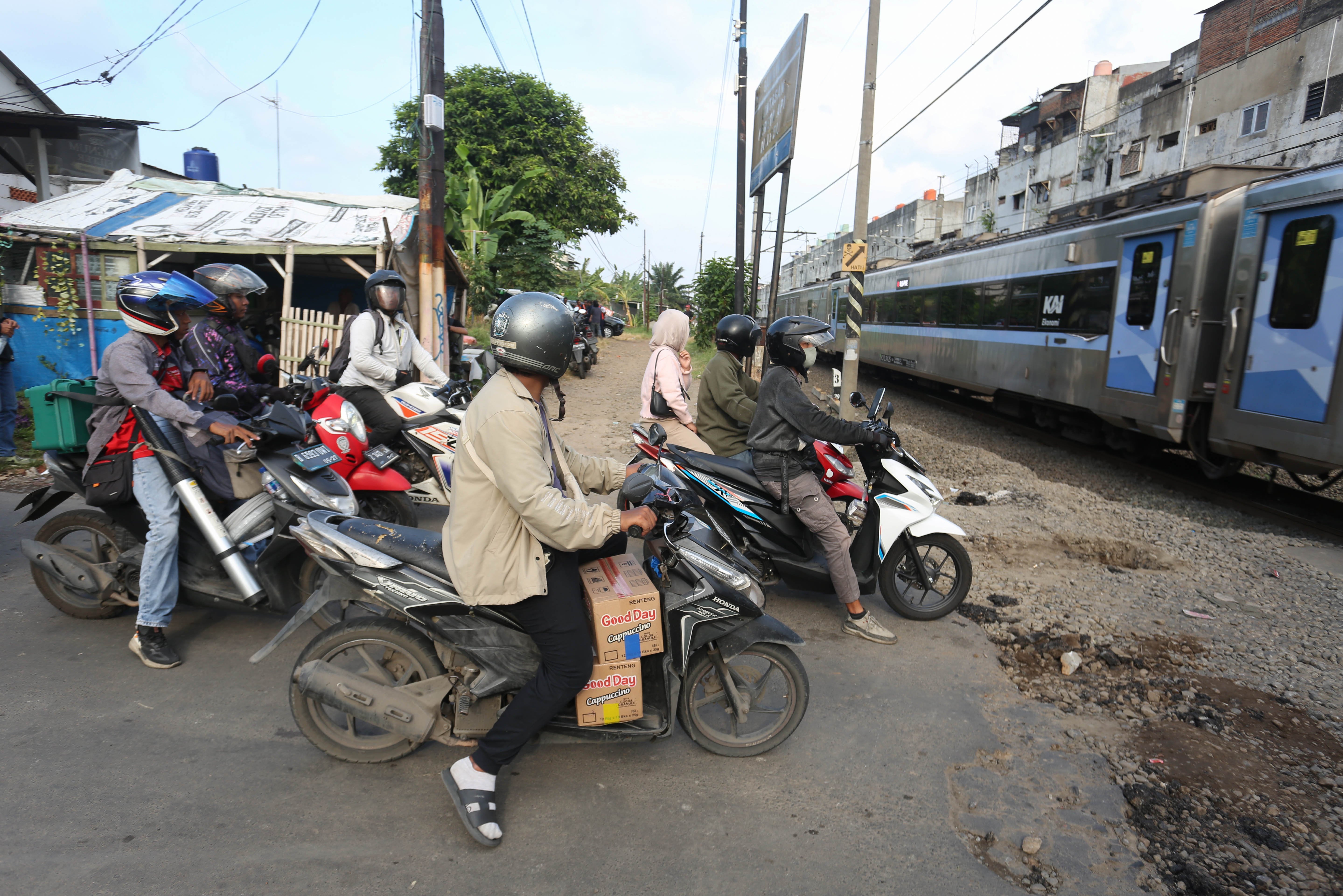 Pengendara menunggu kereta api melintas di perlintasan sebidang di Jalan Ampera, Kota Bekasi, Jawa Barat, Senin (27/4/2026). PT Kereta Api Indonesia (KAI) Persero menyatakan akan menutup berbagai jalur perlintasan kereta api sebidang yang tidak memenuhi syarat keselamatan menyusul dua tragedi yang melibatkan KRL Commuter Line dengan Taksi Green SM dan KA Argo Bromo Anggrek dengan KRL Commuter Line.