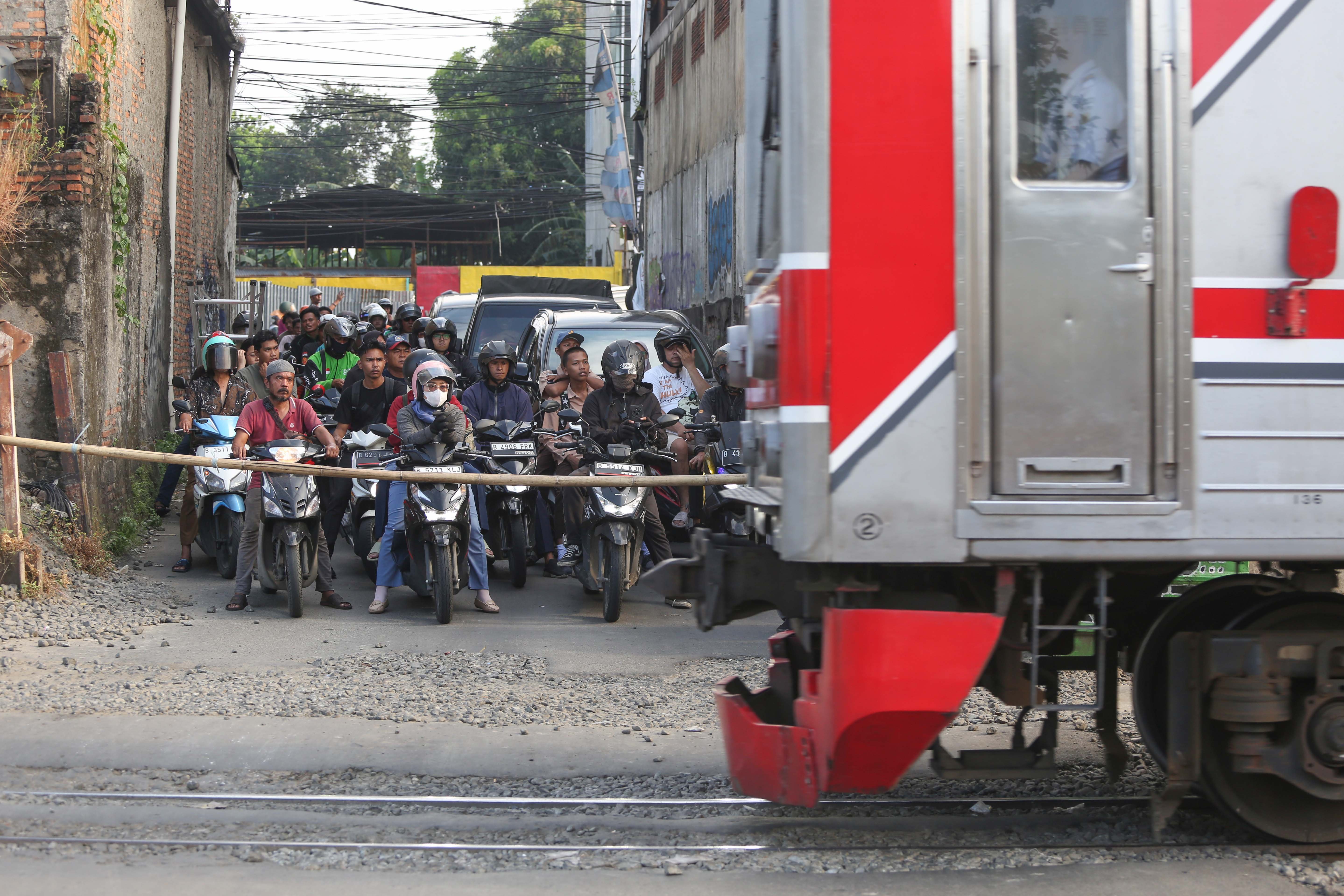 Kereta Commuter Line melintas di dekat perlintasan sebidang di Jalan Ampera, Kota Bekasi, Jawa Barat, Senin (27/4/2026). PT Kereta Api Indonesia (KAI) Persero menyatakan akan menutup berbagai jalur perlintasan kereta api sebidang yang tidak memenuhi syarat keselamatan menyusul dua tragedi yang melibatkan KRL Commuter Line dengan Taksi Green SM dan KA Argo Bromo Anggrek dengan KRL Commuter Line.
