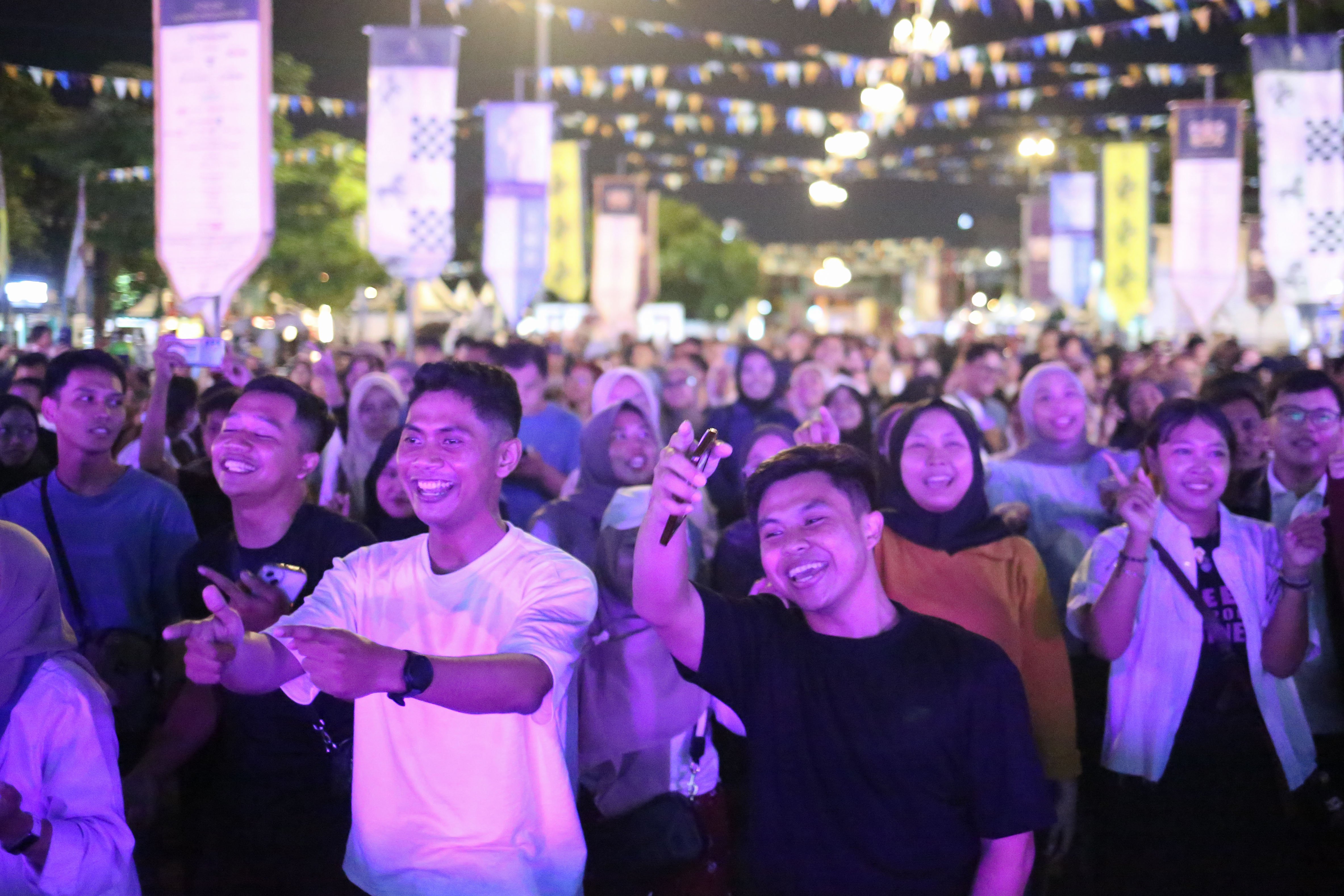 Pengunjung bernyanyi bersama saat grup musik Warga Koplo tampil pada acara Mangkunegaran MakaN-MakaN di Pamedan Pura Mangkunegaran, Solo, Jawa Tengah, Jumat (1/5/2026). Festival yang menghadirkan lebih dari 80 tenant kuliner dan non-kuliner dalam rangka memperingati hari jadinya Pura Mangkunegaran ini berlangsung hingga 3 Mei 2026.