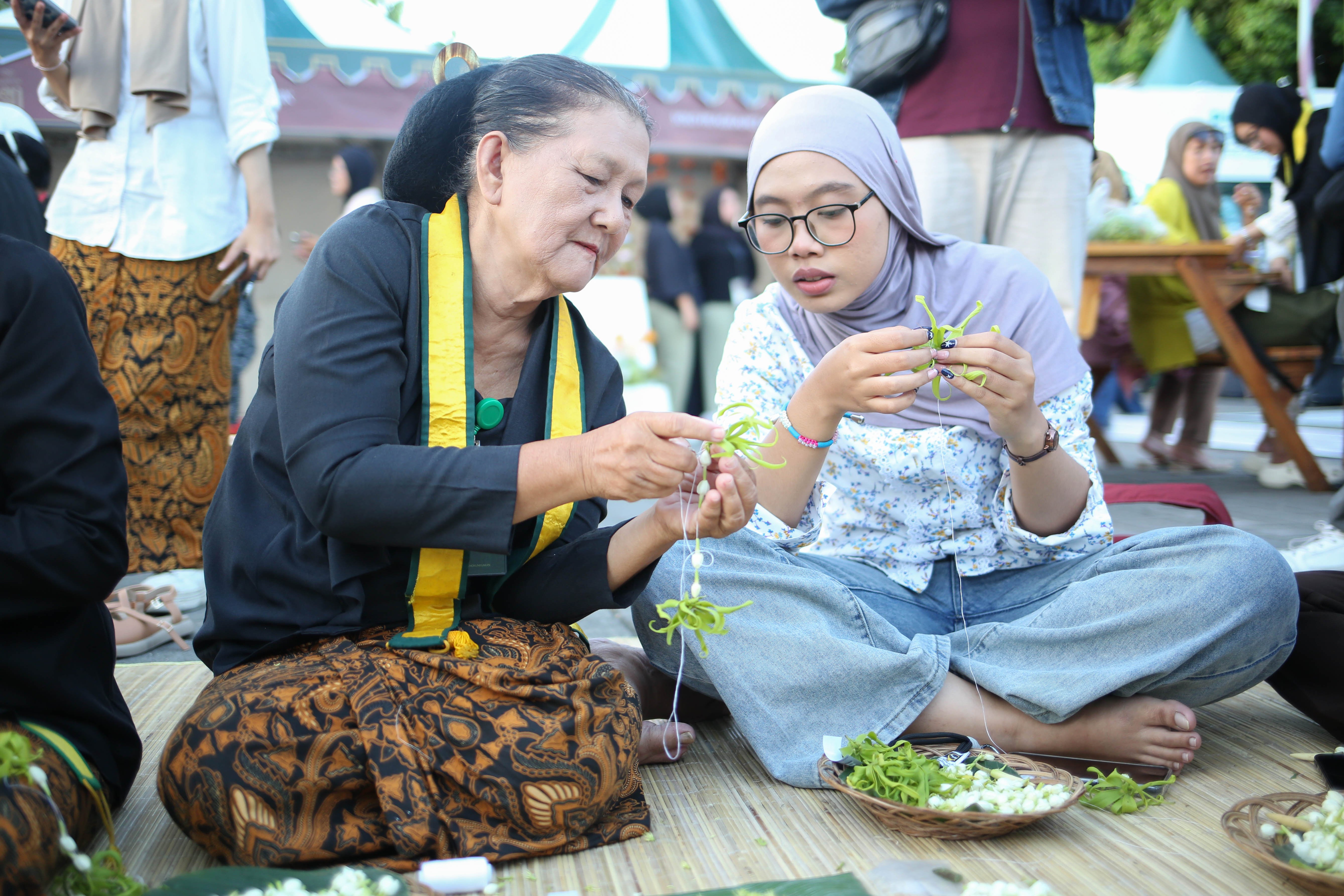 Pengunjung mengikuti pelatihan meronce bunga buntal pada acara Mangkunegaran MakaN-MakaN di Pamedan Pura Mangkunegaran, Solo, Jawa Tengah, Jumat (1/5/2026). Festival yang menghadirkan lebih dari 80 tenant kuliner dan non-kuliner dalam rangka memperingati hari jadinya Pura Mangkunegaran ini berlangsung hingga 3 Mei 2026.