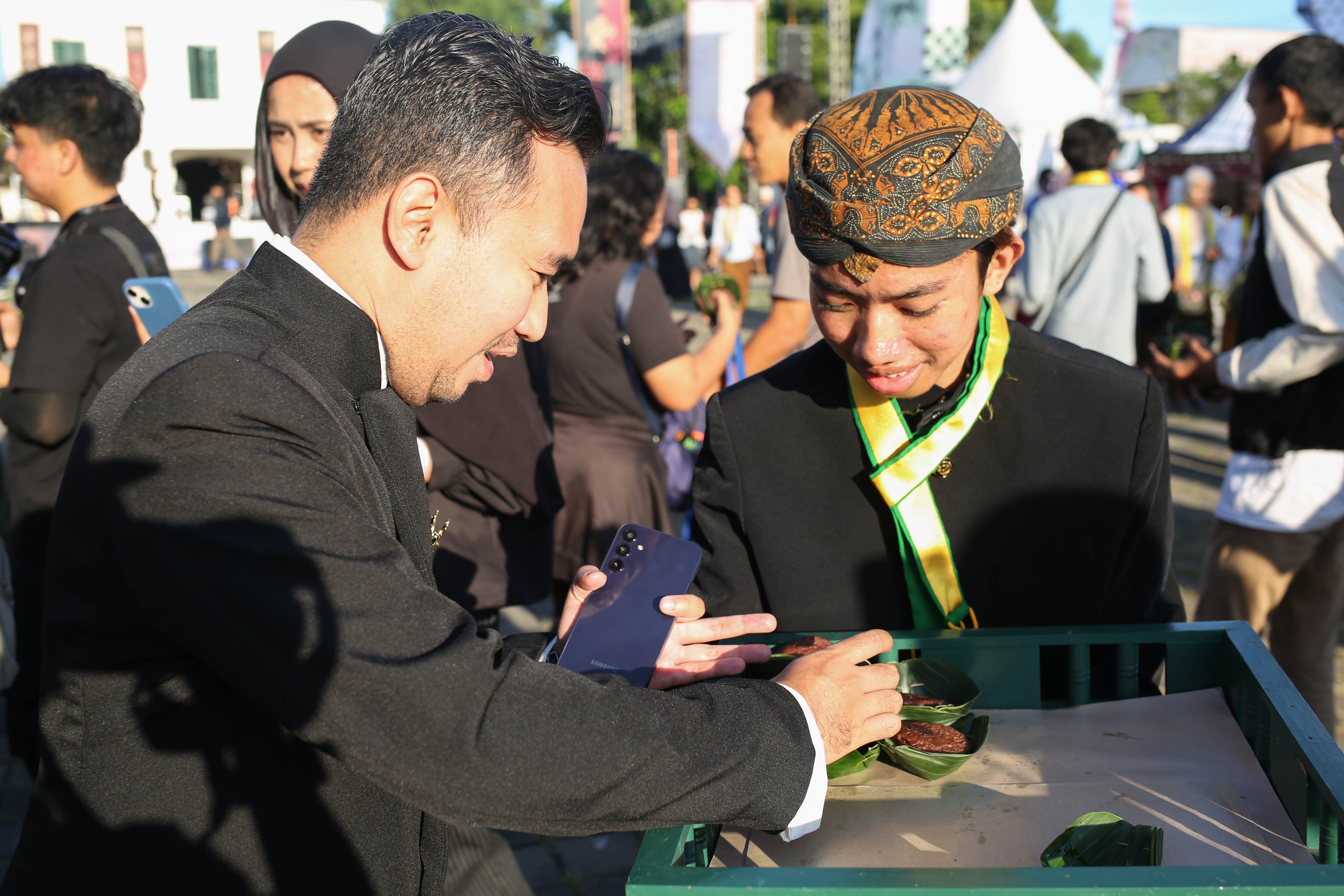 Pengunjung mengambil kue apem yang dibagikan saat pembukaan acara Mangkunegaran MakaN-MakaN di Pamedan Pura Mangkunegaran, Solo, Jawa Tengah, Jumat (1/5/2026). Festival yang menghadirkan lebih dari 80 tenant kuliner dan non-kuliner dalam rangka memperingati hari jadinya Pura Mangkunegaran ini berlangsung hingga 3 Mei 2026.