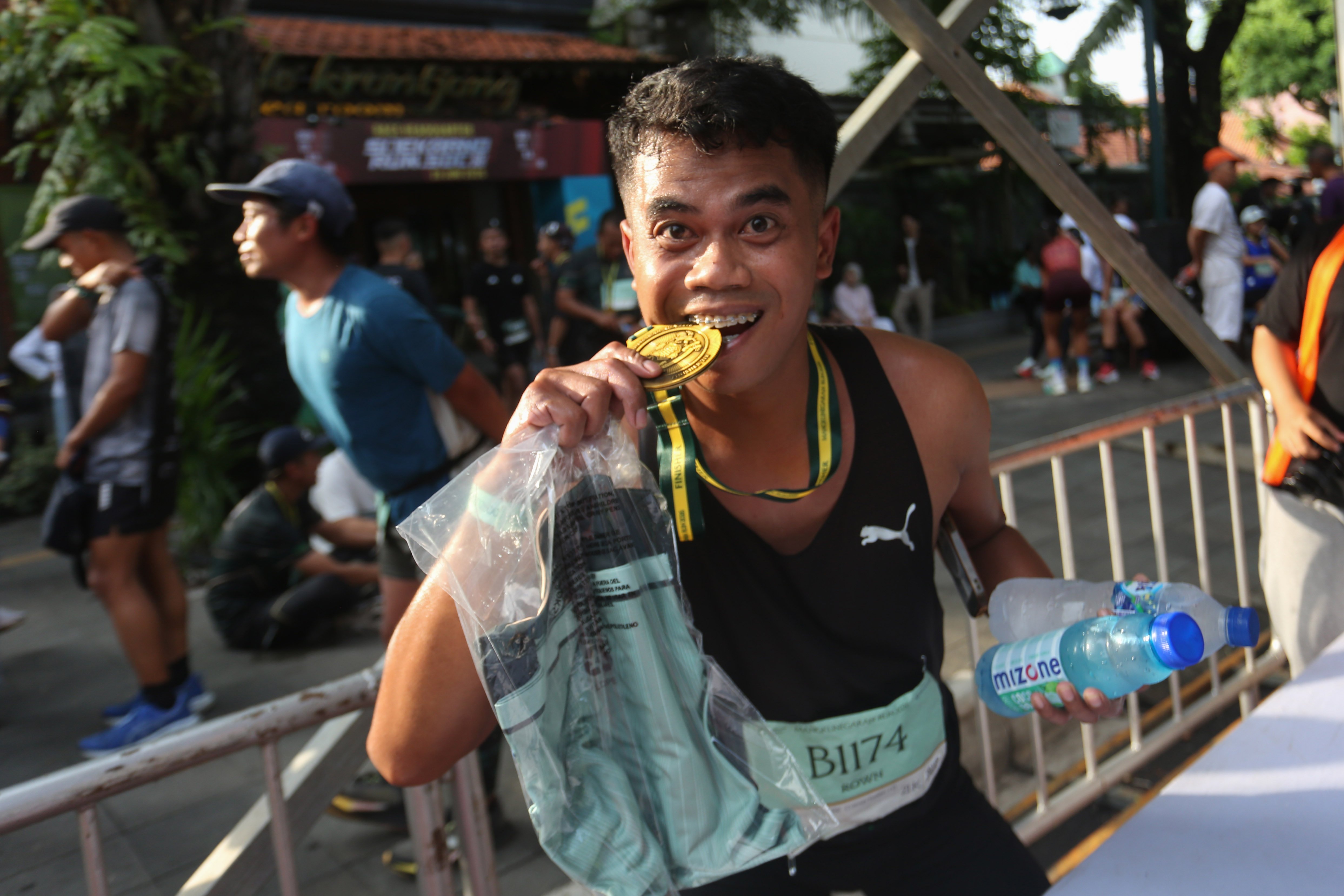 Peserta menggigit medali setelah berhasil menyelesaikan rute pada Mangkunegaran Run 2026 di Jalan Gatot Subroto, Solo, Jawa Tengah, Minggu (3/5/2026). Ajang yang digelar dalam rangka adeging atau peringatan hari jadi Pura Mangkunegaran ke-269 ini diikuti oleh 7.750 peserta dari berbagai daerah Indonesia dengan 22 orang pelari diantaranya berasal dari 20 negara.