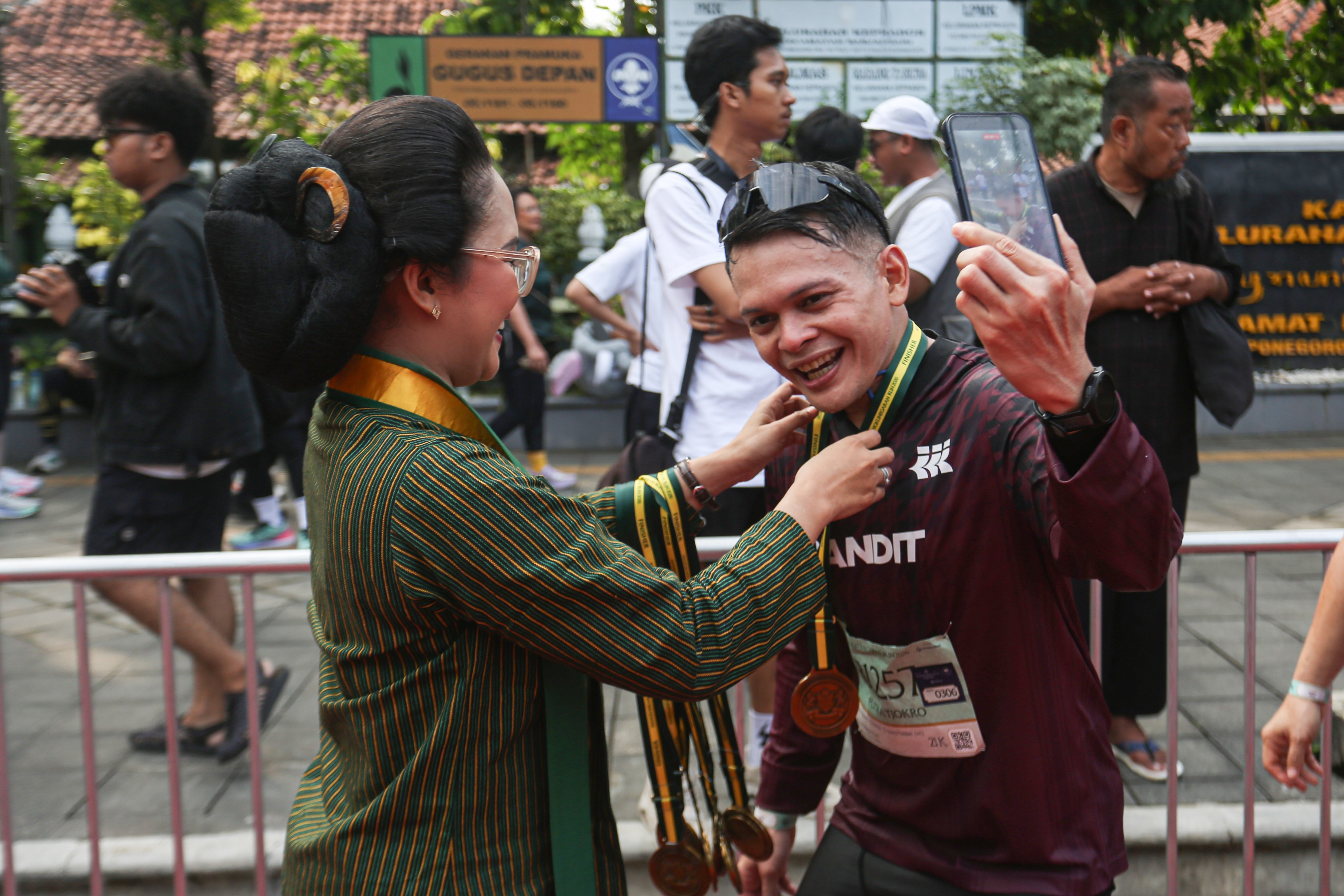 Peserta mendapatkan medali setelah berhasil menyelesaikan rute pada Mangkunegaran Run 2026 di Jalan Gatot Subroto, Solo, Jawa Tengah, Minggu (3/5/2026). Ajang yang digelar dalam rangka adeging atau peringatan hari jadi Pura Mangkunegaran ke-269 ini diikuti oleh 7.750 peserta dari berbagai daerah Indonesia dengan 22 orang pelari diantaranya berasal dari 20 negara.