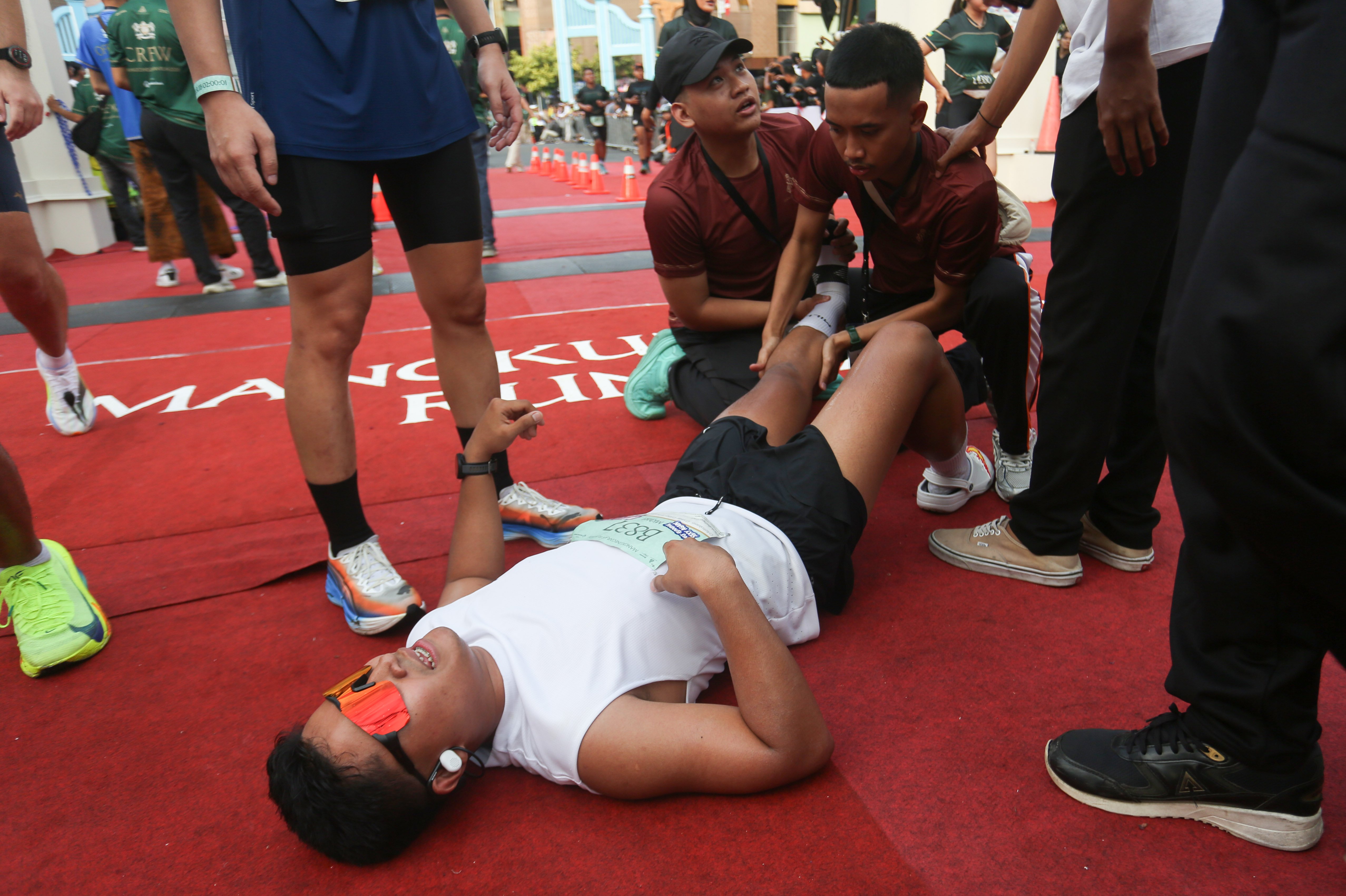 Peserta mengalami kram kaki saat memasuki garis finish Mangkunegaran Run 2026 di Jalan Gatot Subroto, Solo, Jawa Tengah, Minggu (3/5/2026). Ajang yang digelar dalam rangka adeging atau peringatan hari jadi Pura Mangkunegaran ke-269 ini diikuti oleh 7.750 peserta dari berbagai daerah Indonesia dengan 22 orang pelari diantaranya berasal dari 20 negara.
