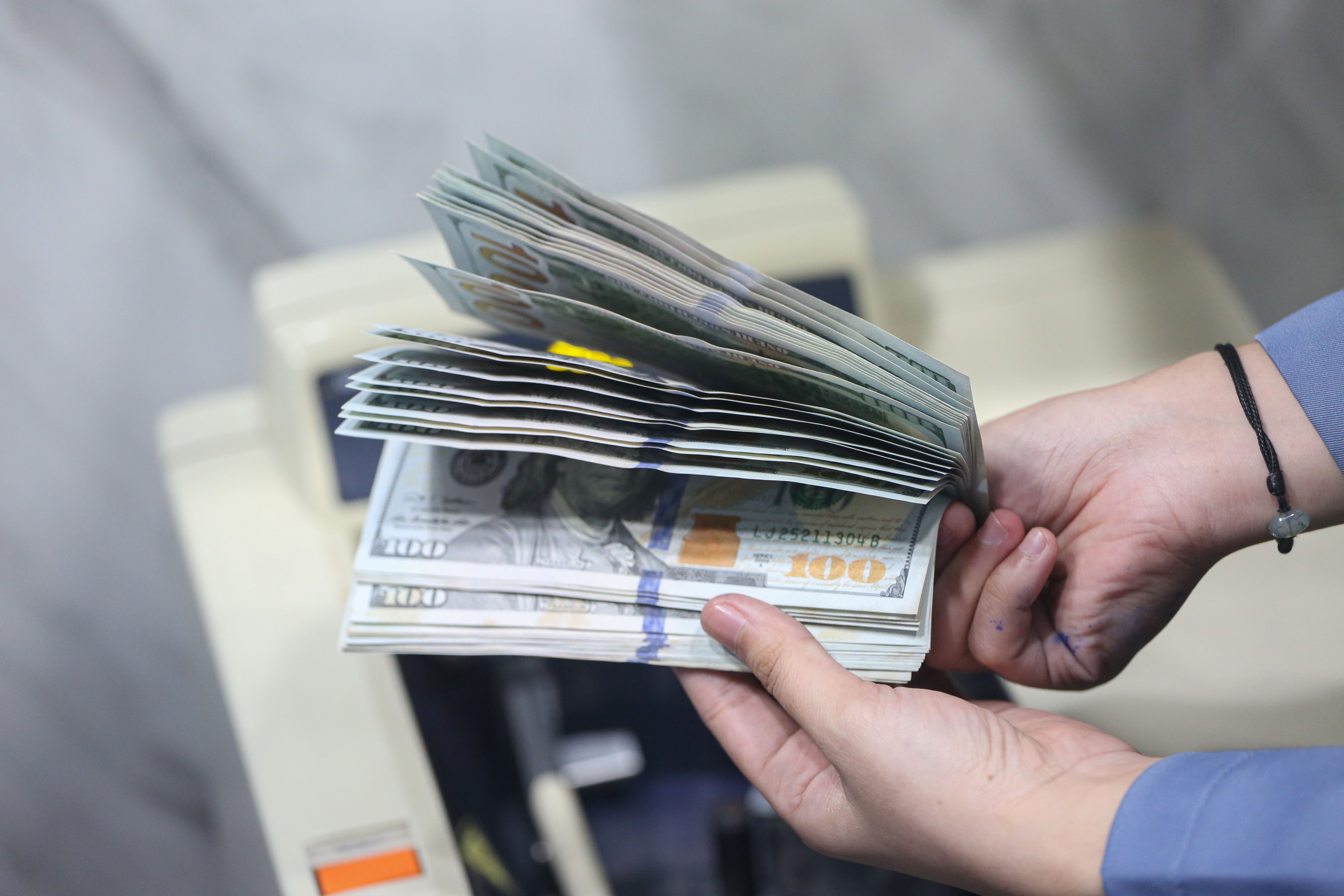 Petugas menghitung pecahan mata uang dolar Amerika Serikat (AS) di gerai penukaran uang asing di Jakarta, Rabu (18/5/2026). Nilai tukar rupiah rupiah terhadap dolar AS ditutup melemah Rp 17.668 pada perdagangan hari ini dari sebelumnya Rp 17.597 per dolar AS.