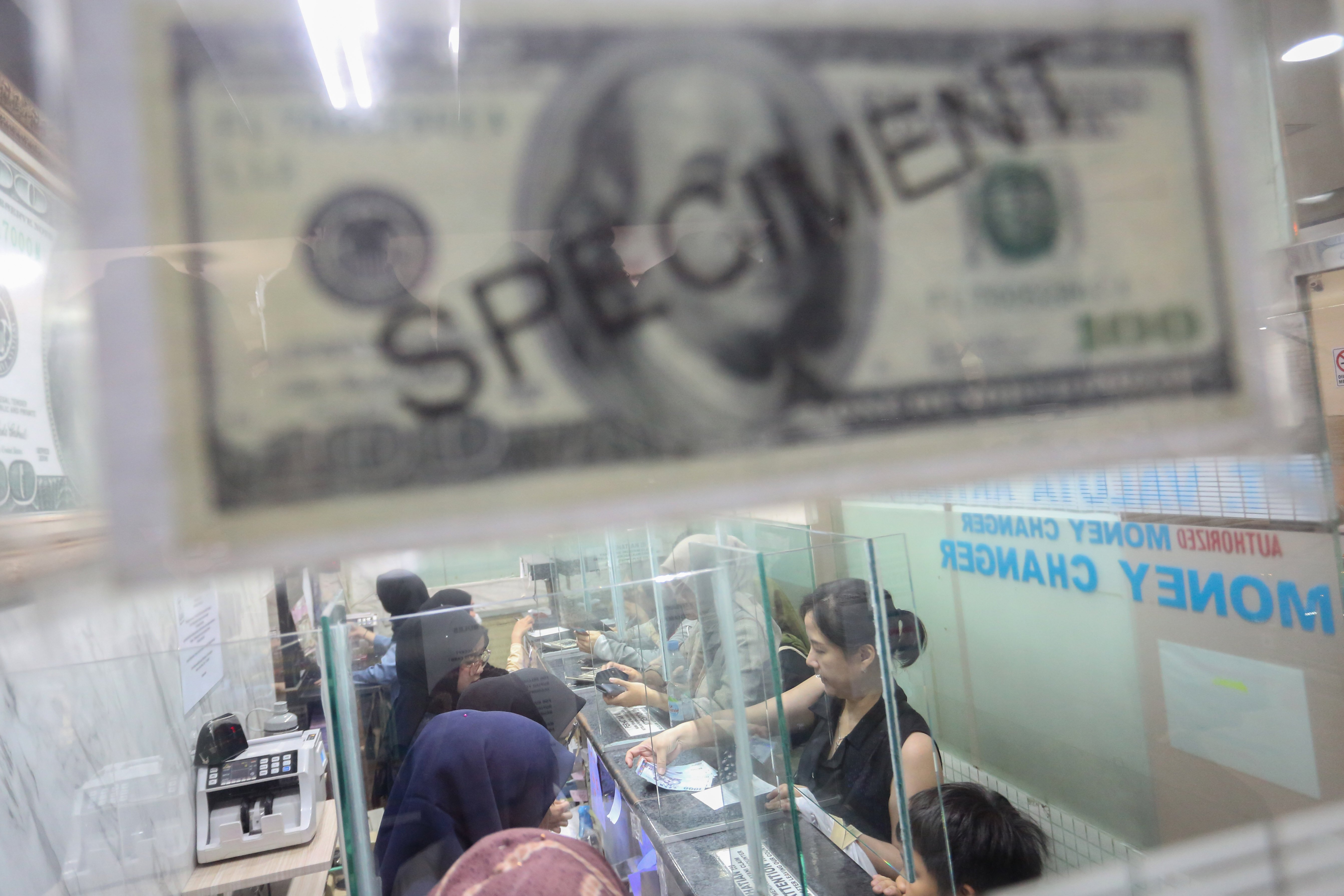 Petugas melayani warga yang hendak menukarkan mata uang dolar Amerika Serikat (AS) di gerai penukaran uang asing di Jakarta, Rabu (18/5/2026). Nilai tukar rupiah rupiah terhadap dolar AS ditutup melemah Rp 17.668 pada perdagangan hari ini dari sebelumnya Rp 17.597 per dolar AS.