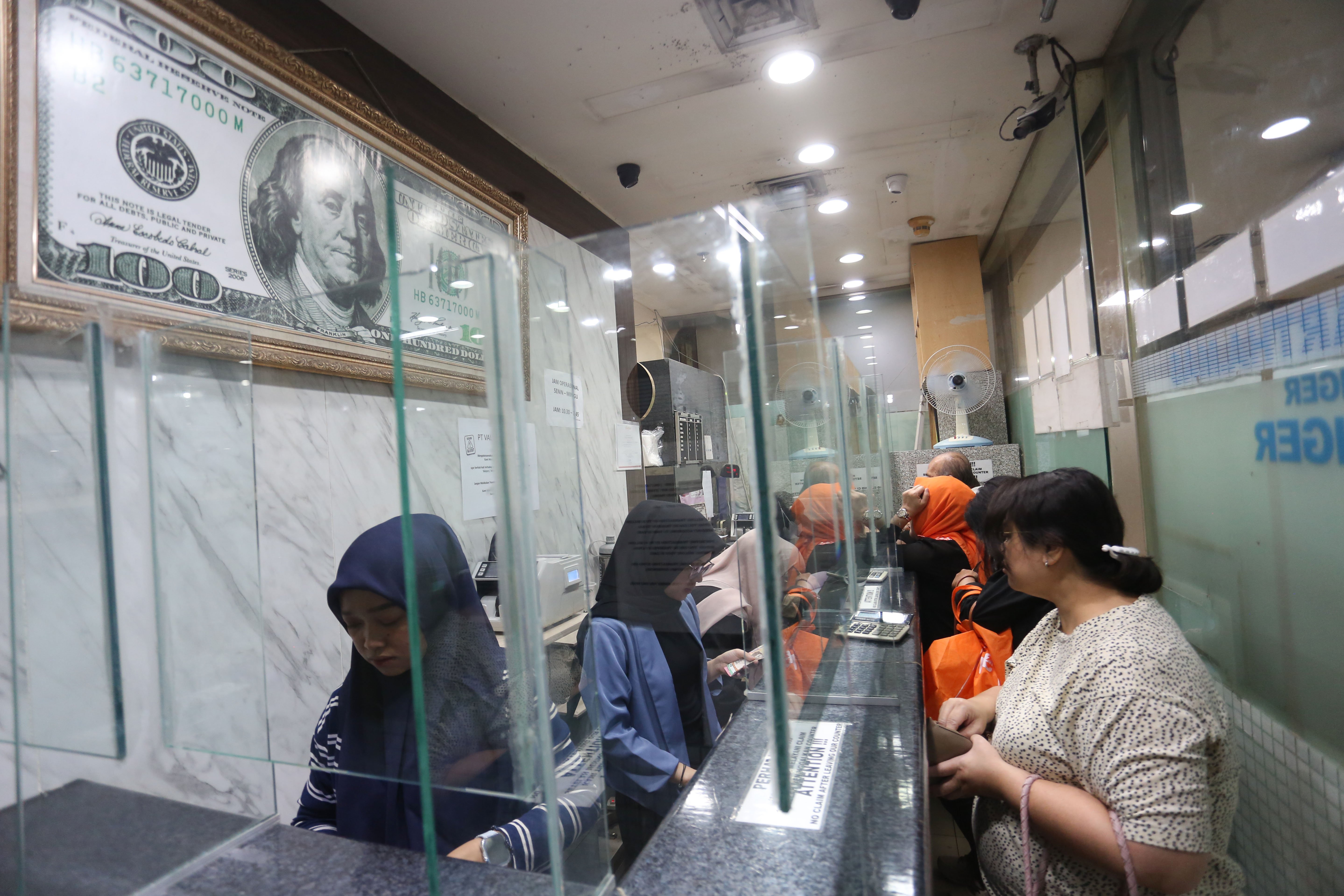 Petugas melayani warga yang hendak menukarkan mata uang di gerai penukaran uang asing di Jakarta, Rabu (18/5/2026). Nilai tukar rupiah rupiah terhadap dolar AS ditutup melemah Rp 17.668 pada perdagangan hari ini dari sebelumnya Rp 17.597 per dolar AS.
