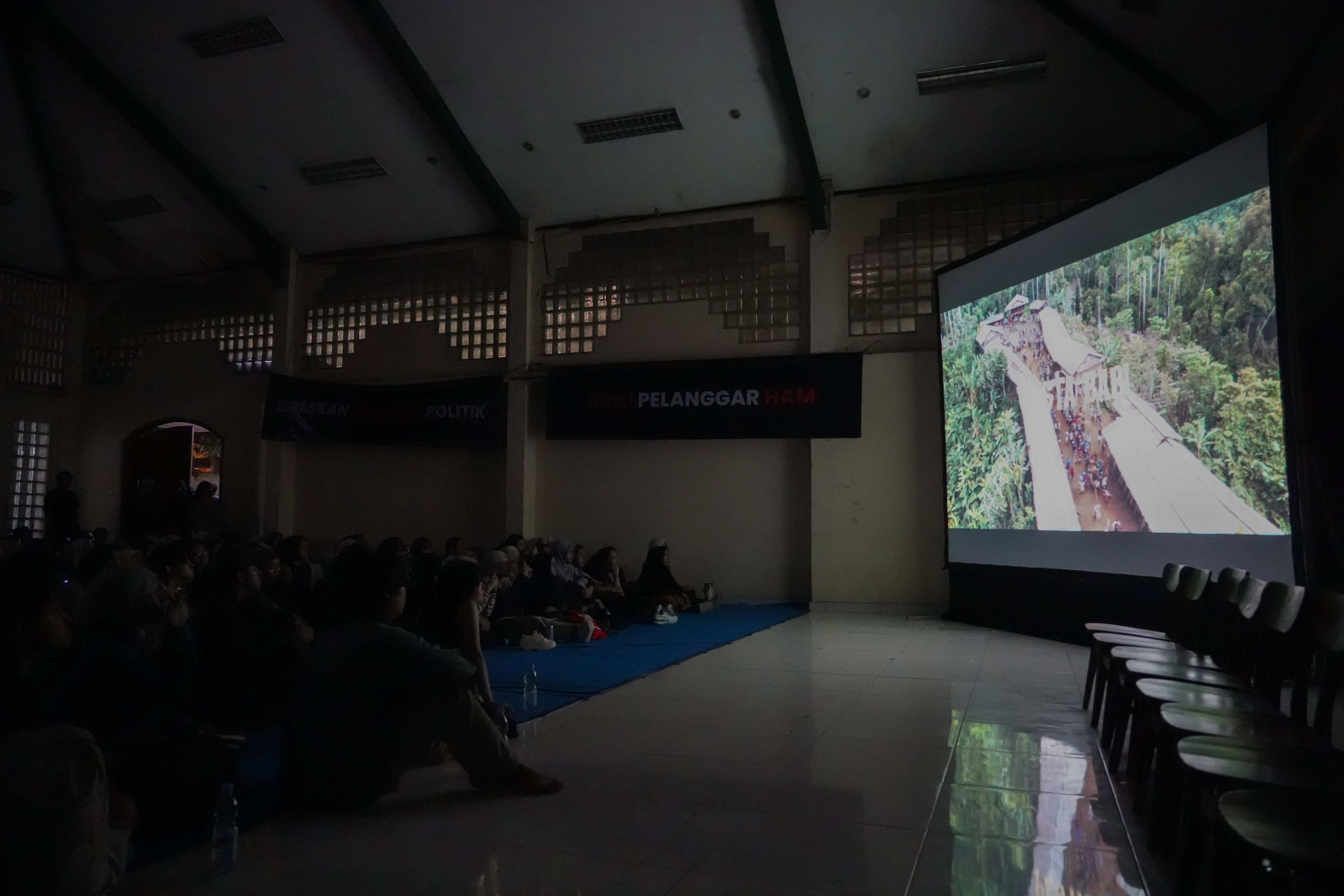 Suasana nonton bareng film Pesta Babi di sekretariat Perhimpunan Mahasiswa Katolik Republik Indonesia, Menteng, Jakarta Pusat, Sabtu (23/5/2026). Film dokumenter tersebut mengangkat isu mengenai proyek pembangunan di Papua Selatan yang disebut membuat masyarakat adat kehilangan tanah dan ruang hidup akibat ekspansi proyek perkebunan tebu, sawit, hingga food estate.