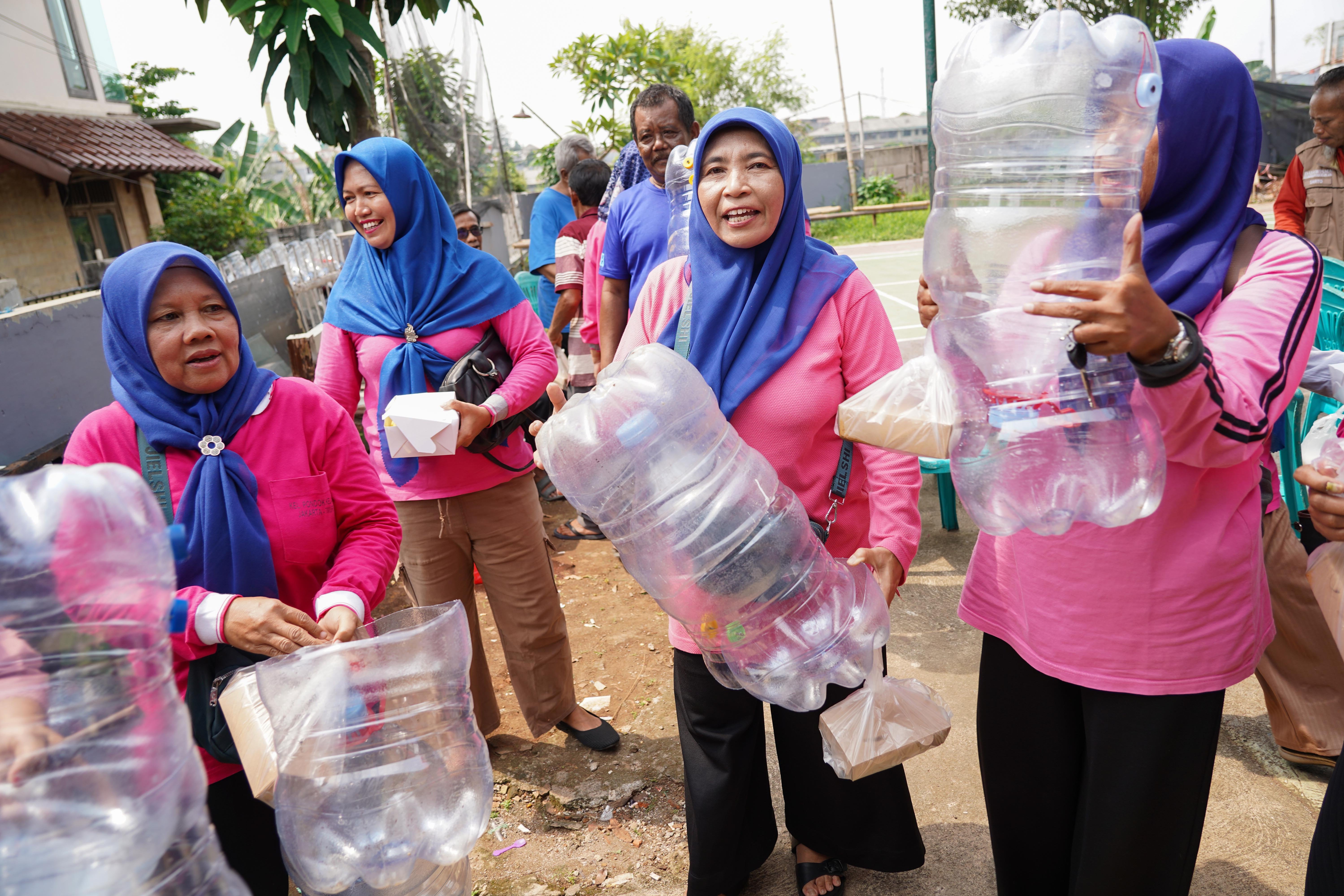 Warga membawa galon bekas untuk didaur ulang menjadi wadah komposter skala rumahan di Taman Akur Warga, Duren Sawit, Jakarta Timur, Jumat (22/5/2026). Kegiatan tersebut dilakukan guna mengajak masyarakat untuk memilah dan mengolah sampah dari rumah.