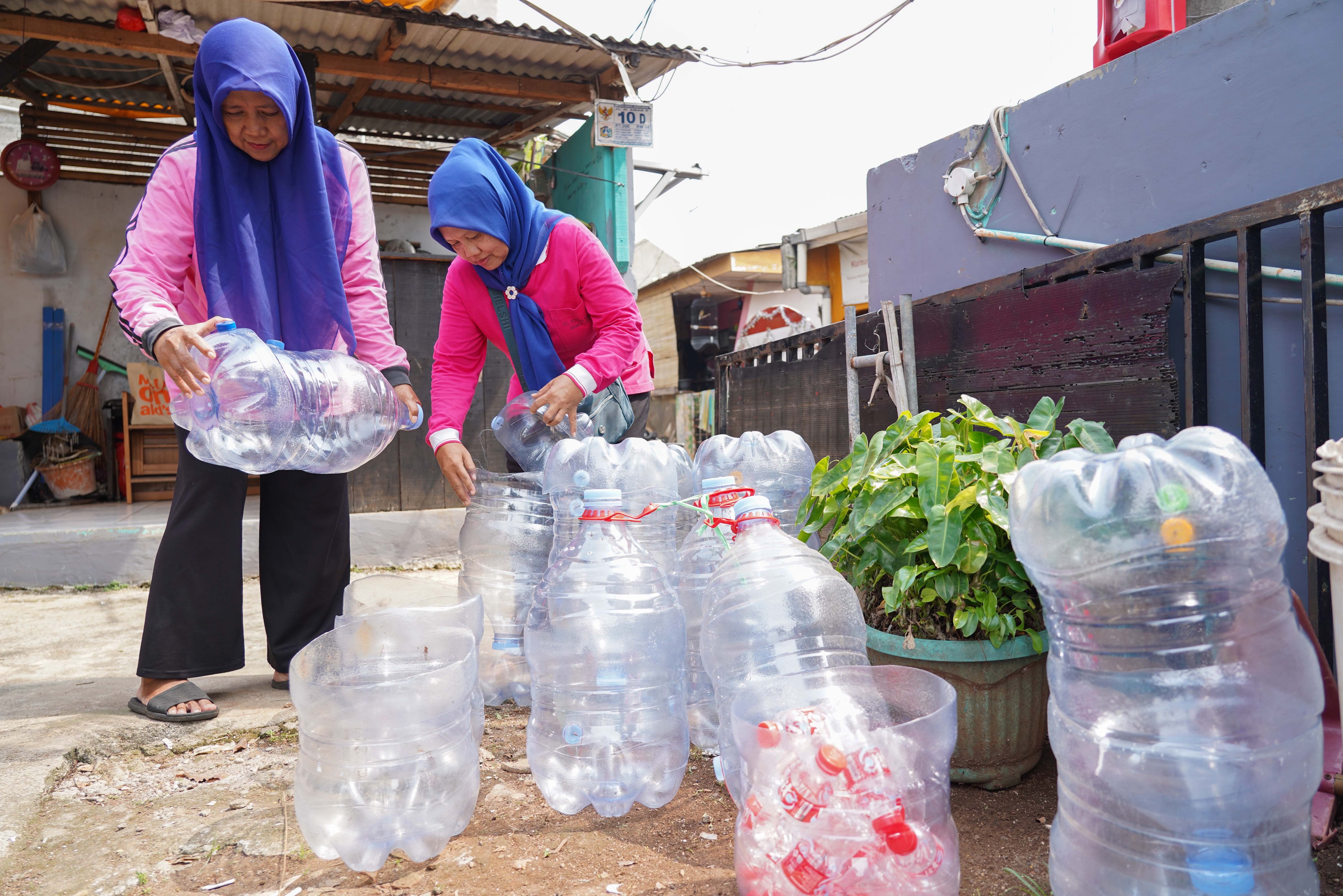 Warga membawa galon bekas untuk didaur ulang menjadi wadah komposter skala rumahan di Taman Akur Warga, Duren Sawit, Jakarta Timur, Jumat (22/5/2026). Kegiatan tersebut dilakukan guna mengajak masyarakat untuk memilah dan mengolah sampah dari rumah.