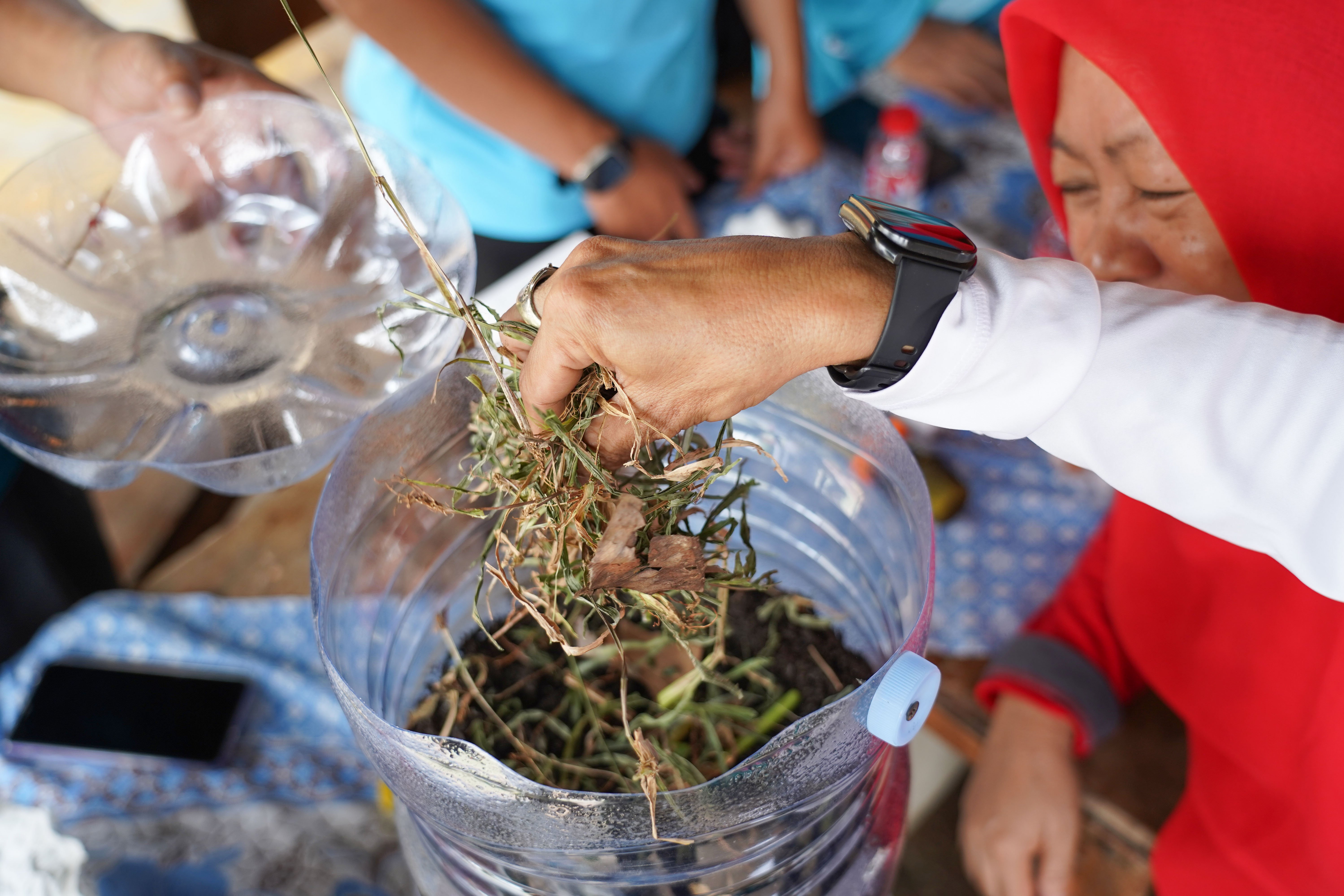 Warga melihat cara pembuatan wadah komposter skala rumahan di Taman Akur Warga, Duren Sawit, Jakarta Timur, Jumat (22/5/2026). Kegiatan tersebut dilakukan guna mengajak masyarakat untuk memilah dan mengolah sampah dari rumah.
