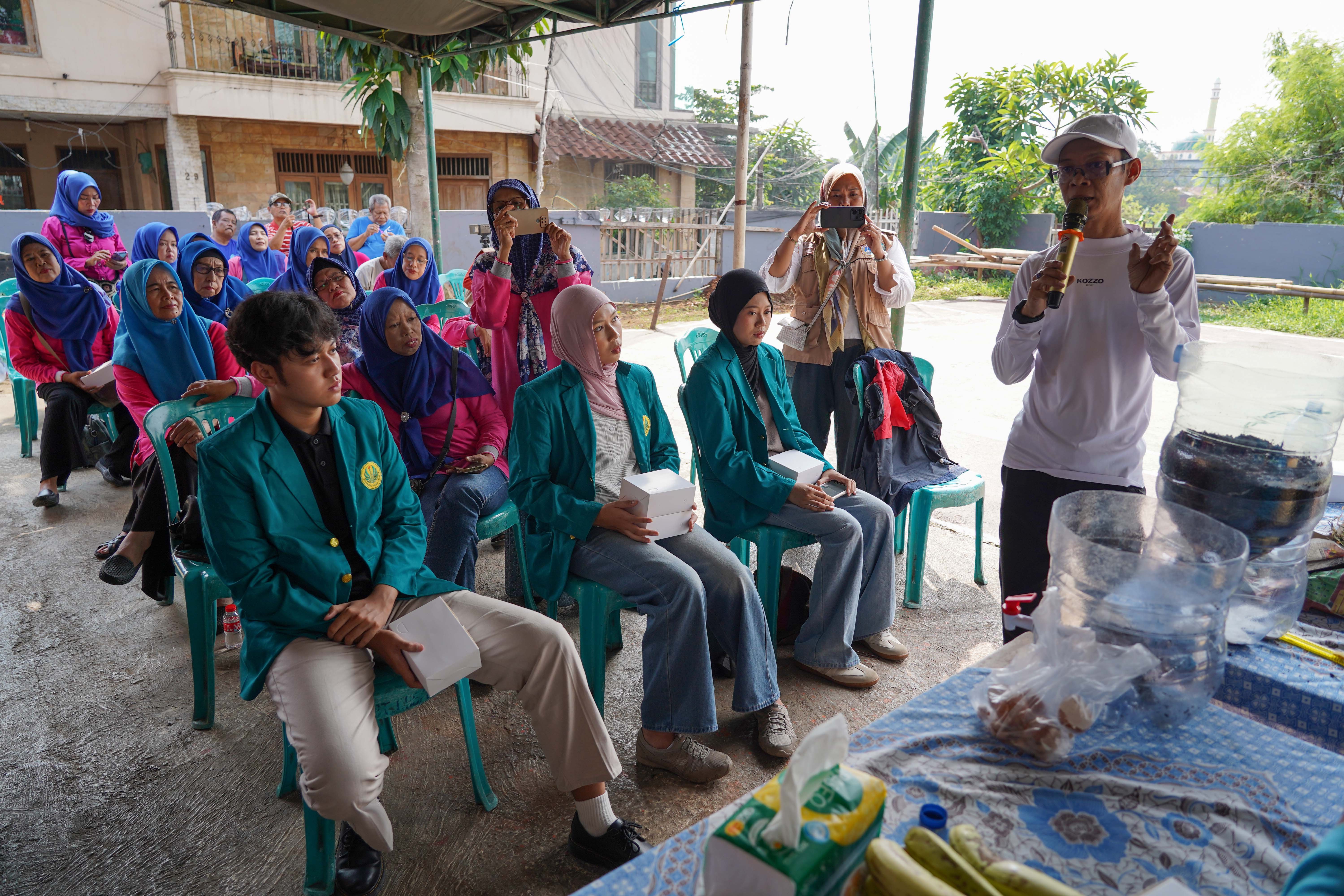Pengurus Bank Sampah Persatuan, Rahmat (kanan) menyampaikan edukasi pembuatan wadah komposter skala rumahan di Taman Akur Warga, Duren Sawit, Jakarta Timur, Jumat (22/5/2026). Kegiatan tersebut dilakukan guna mengajak masyarakat untuk memilah dan mengolah sampah dari rumah.