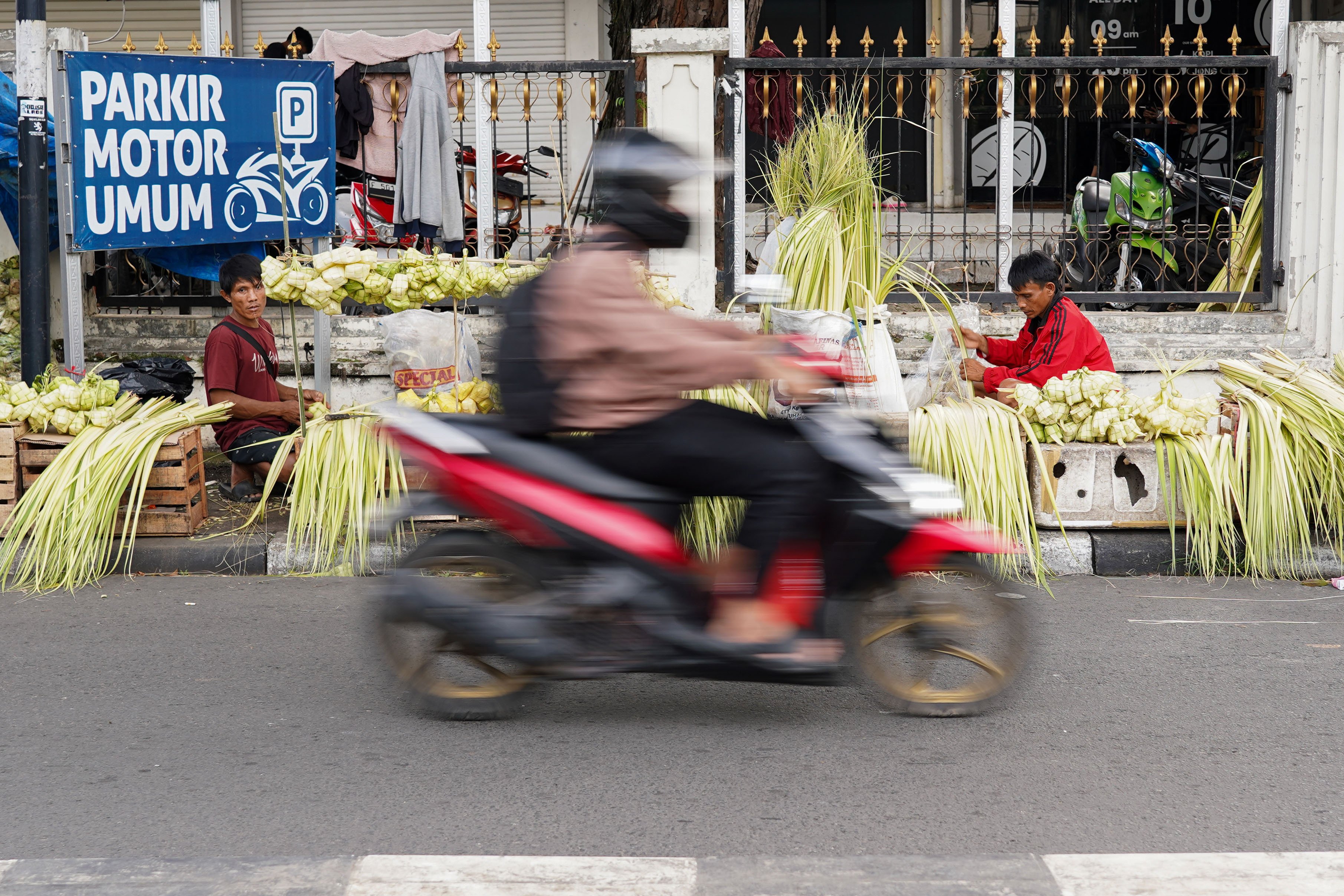 Pedagang menganyam ketupat yang dijualnya di Pasar Pondok Labu, Jakarta Selatan, Senin (25/5/2026). Ketupat tersebut dijual Rp 10 ribu per ikatnya atau Rp 1.000 per ketupat dan untuk daunnya saja yang belum dianyam dihargai Rp 500 per helai.