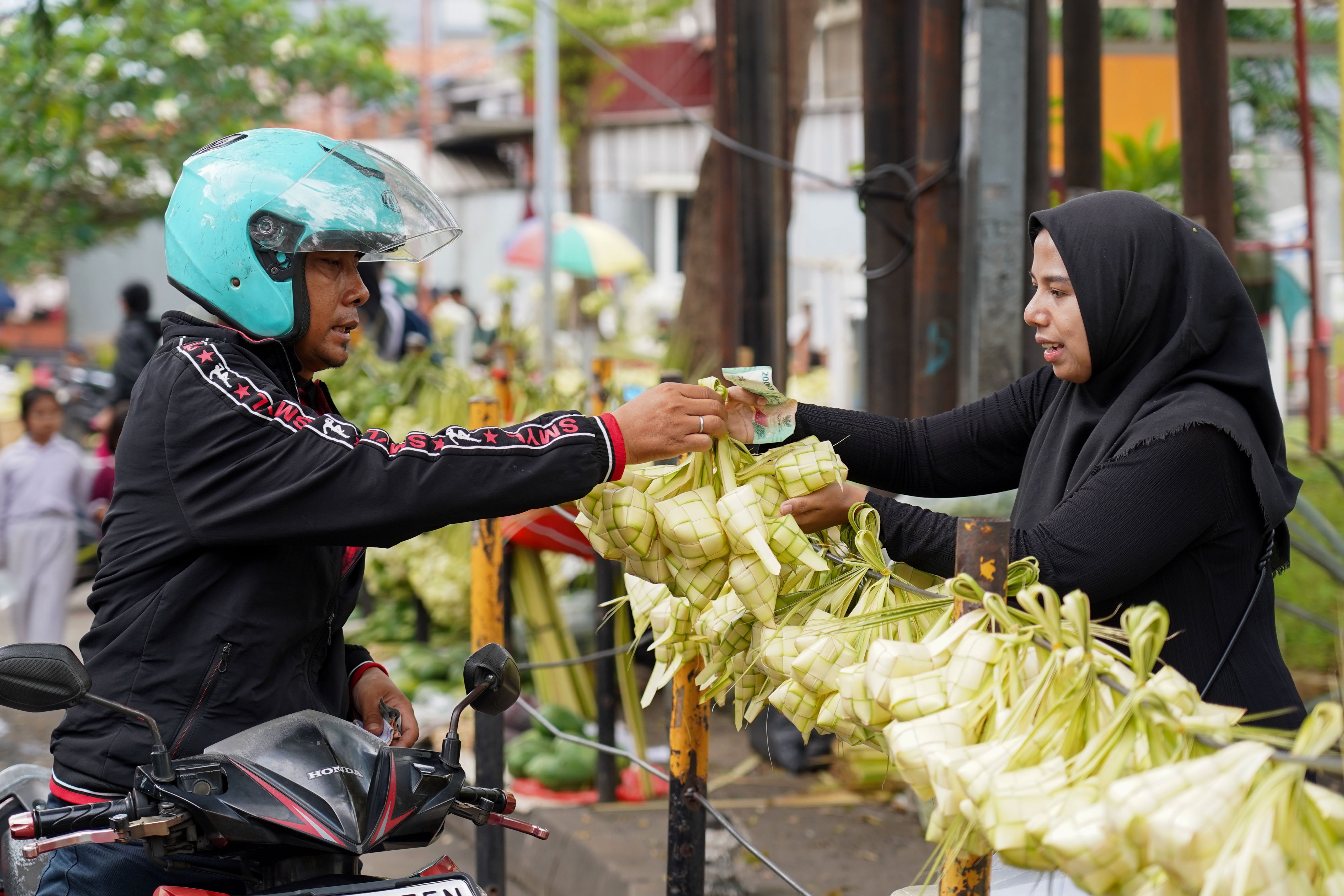 Warga membeli ketupat di Pasar Pondok Labu, Jakarta Selatan, Senin (25/5/2026). Ketupat tersebut dijual Rp 10 ribu per ikatnya atau Rp 1.000 per ketupat dan untuk daunnya saja yang belum dianyam dihargai Rp 500 per helai.