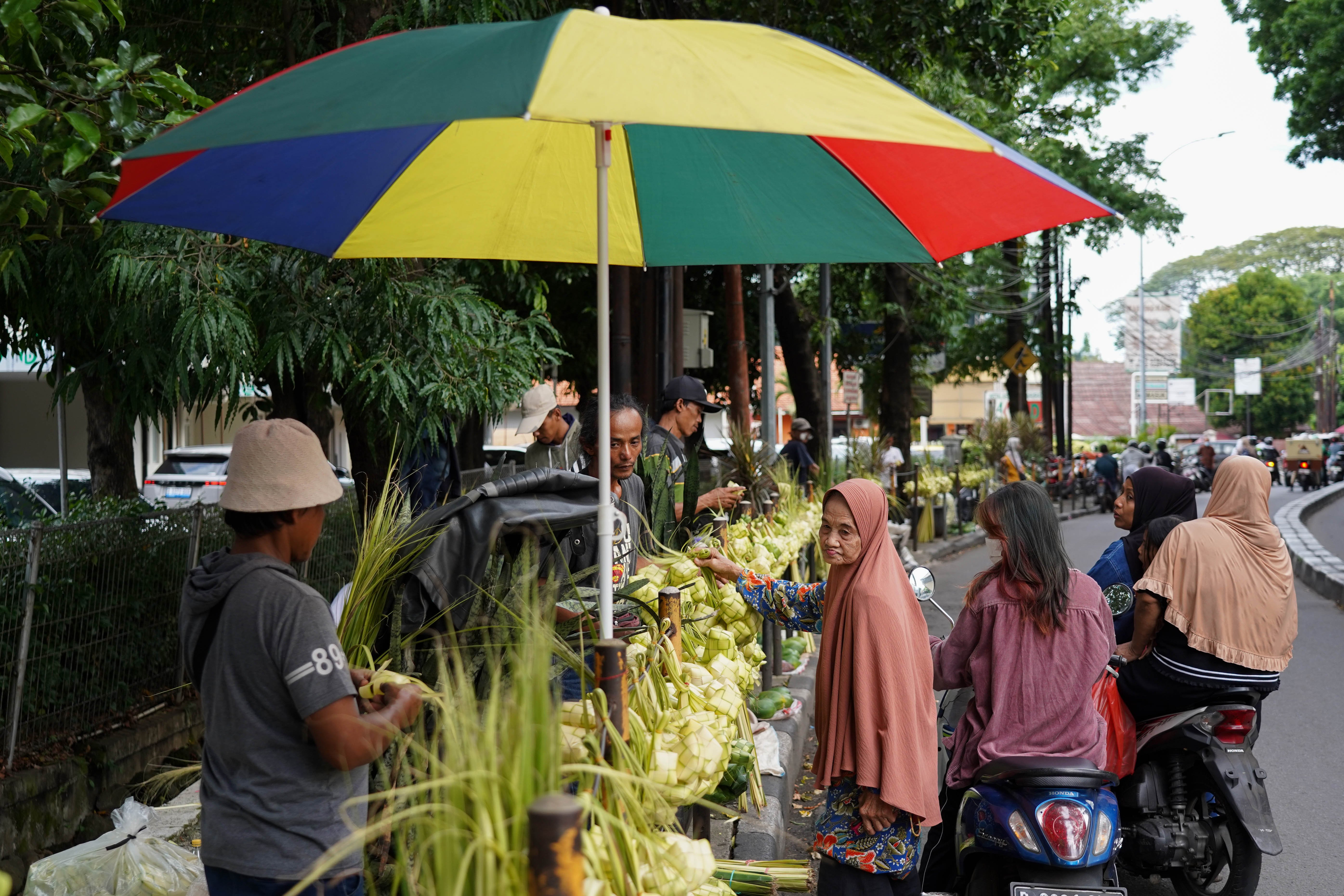 Calon pembeli melihat ketupat yang dijajakan di Pasar Pondok Labu, Jakarta Selatan, Senin (25/5/2026). Ketupat tersebut dijual Rp 10 ribu per ikatnya atau Rp 1.000 per ketupat dan untuk daunnya saja yang belum dianyam dihargai Rp 500 per helai.