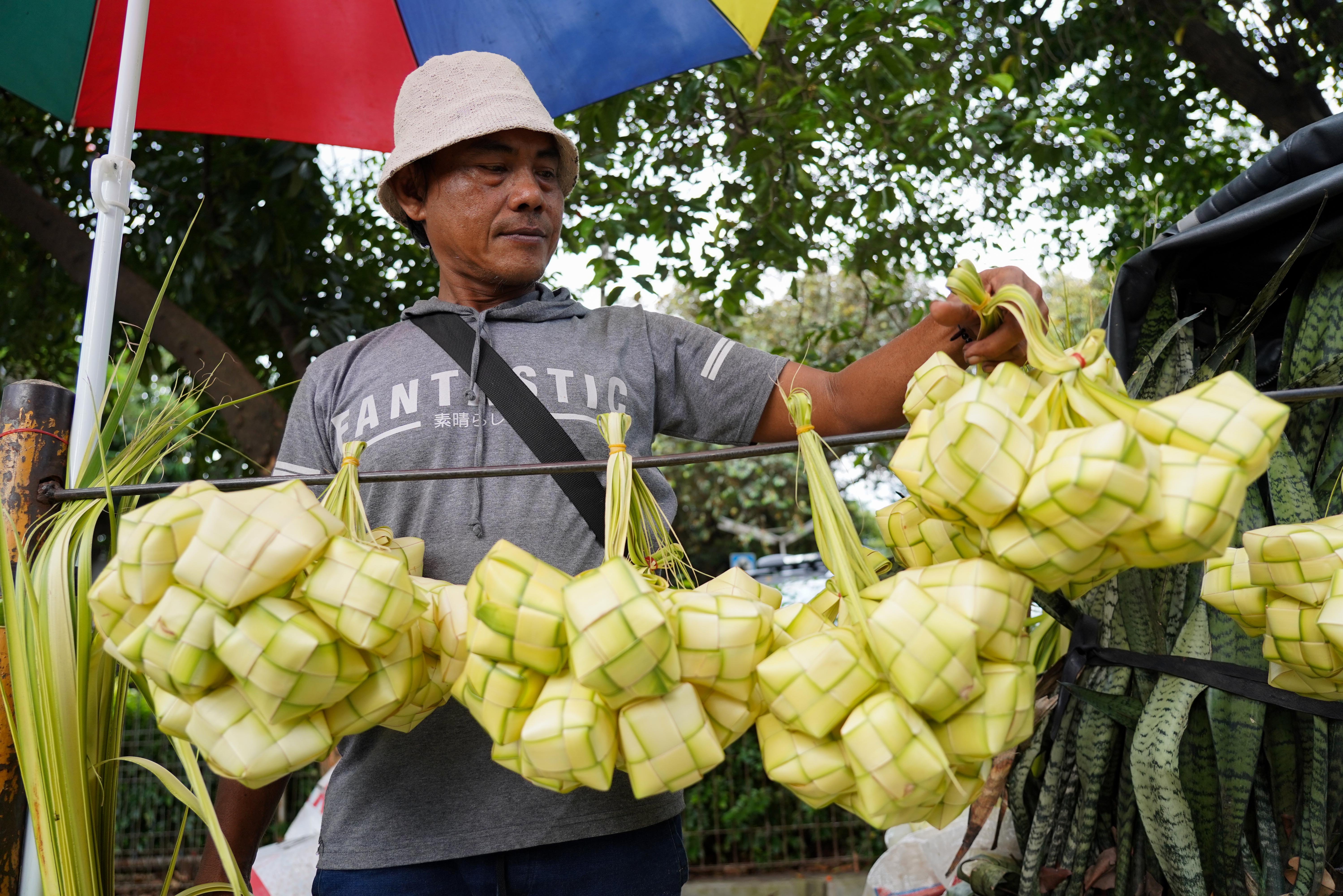 Pedagang menata ketupat yang dijualnya di Pasar Pondok Labu, Jakarta Selatan, Senin (25/5/2026). Ketupat tersebut dijual Rp 10 ribu per ikatnya atau Rp 1.000 per ketupat dan untuk daunnya saja yang belum dianyam dihargai Rp 500 per helai.