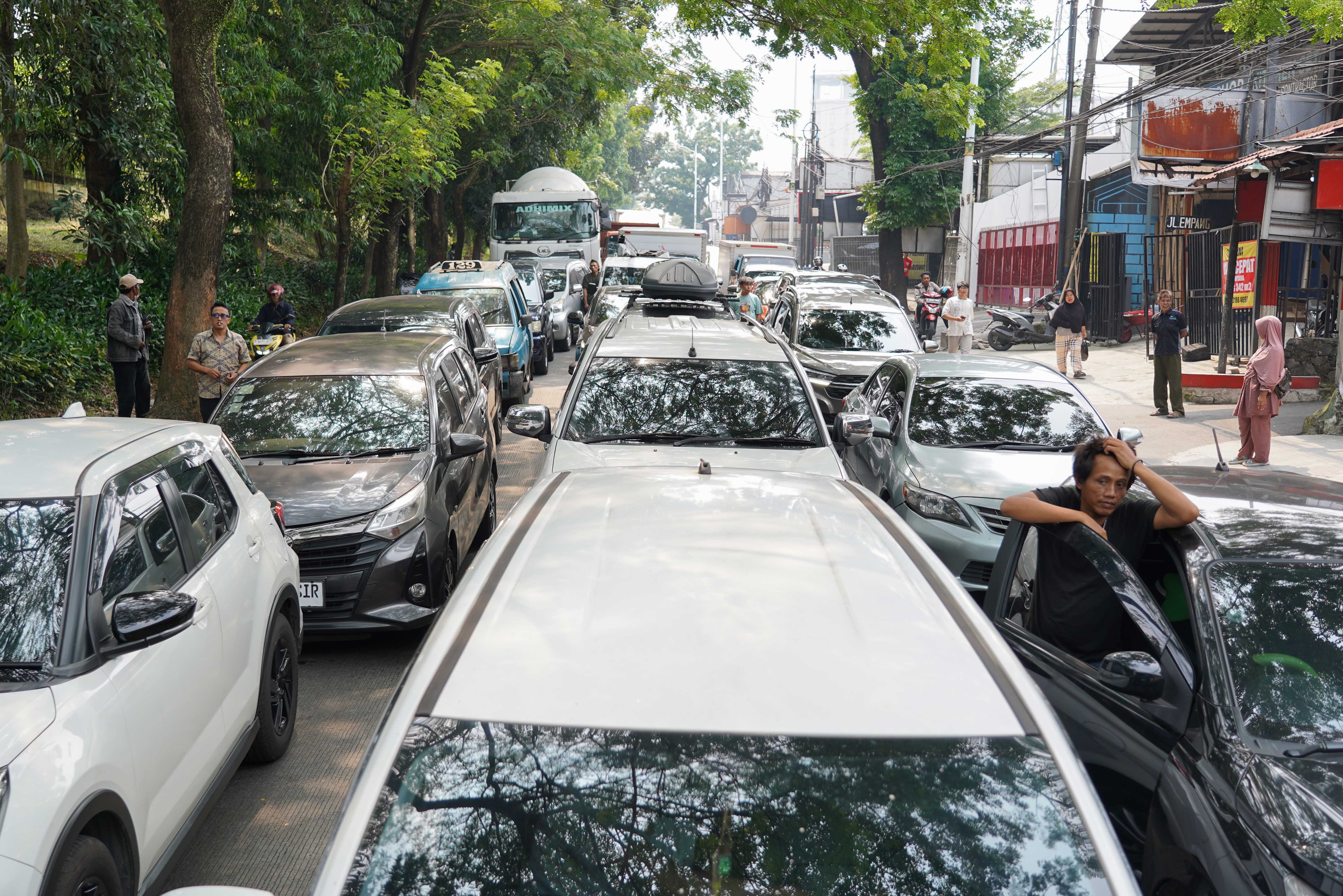 Pengendara terjebak kemacetan akibat amblasnya Jalan Raya Lenteng Agung, Jagakarsa, Jakarta Selatan, Jumat (29/5/2026). Akibat jalan tersebut amblas sedalam tiga meter dengan lebar empat meter ini membuat arus lalu lintas dari arah Jakarta menuju Depok mengalami kemacetan.
