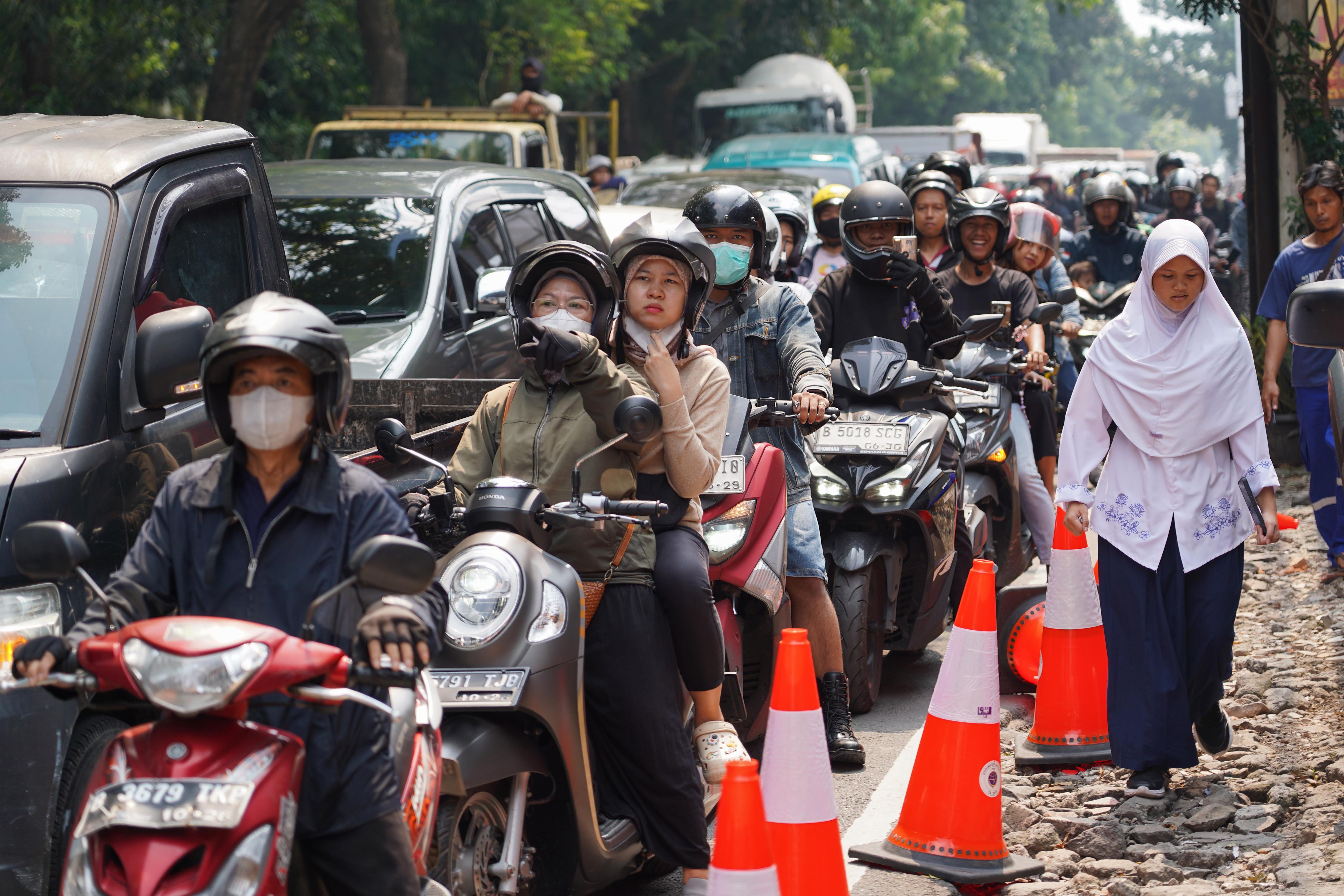 Pengendara terjebak kemacetan akibat amblasnya Jalan Raya Lenteng Agung, Jagakarsa, Jakarta Selatan, Jumat (29/5/2026). Akibat jalan tersebut amblas sedalam tiga meter dengan lebar empat meter ini membuat arus lalu lintas dari arah Jakarta menuju Depok mengalami kemacetan.