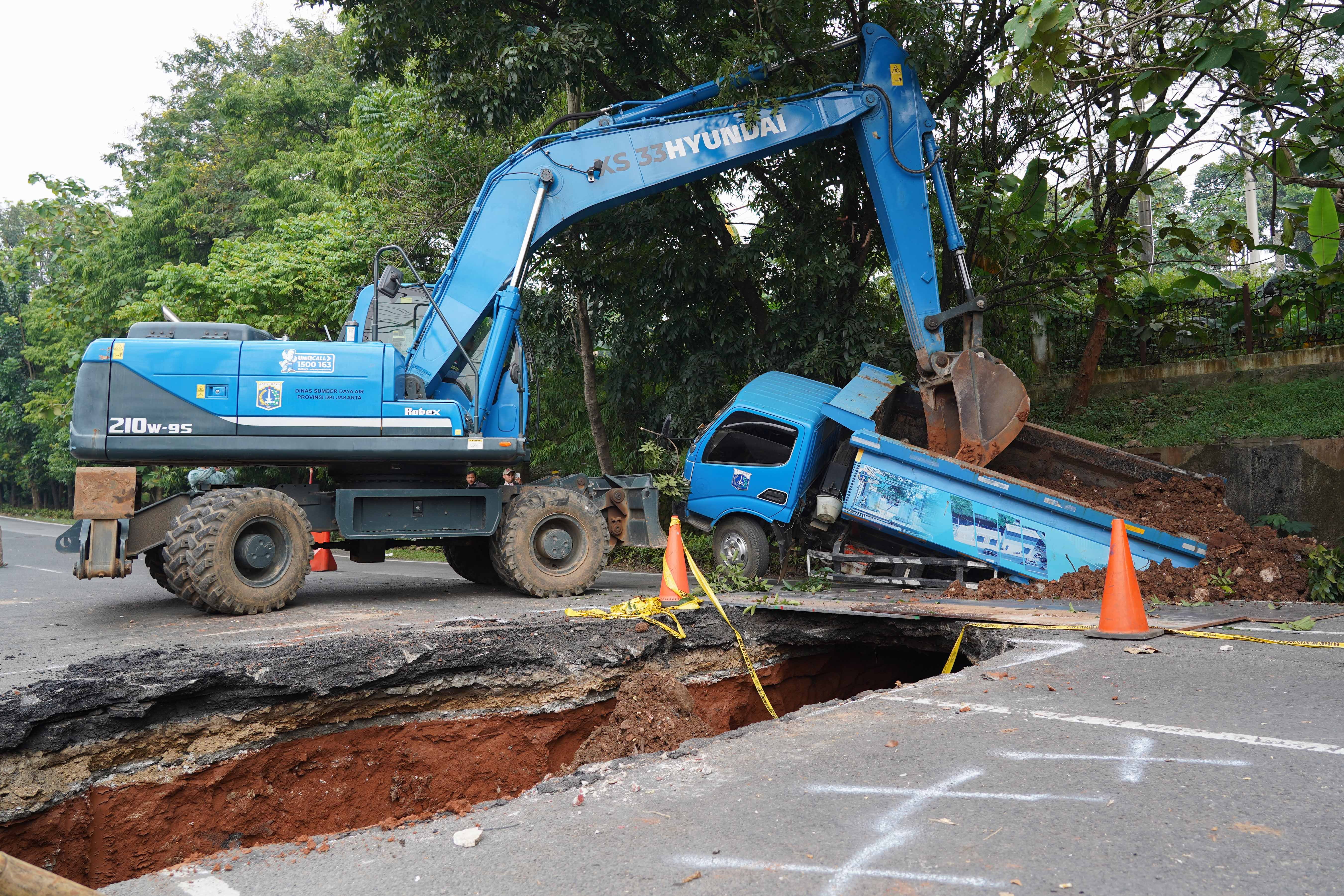 Truk terperosok saat melintas di dekat lubang dari amblasnya Jalan Raya Lenteng Agung, Jagakarsa, Jakarta Selatan, Jumat (29/5/2026). Akibat jalan tersebut amblas sedalam tiga meter dengan lebar empat meter ini membuat arus lalu lintas dari arah Jakarta menuju Depok mengalami kemacetan.
