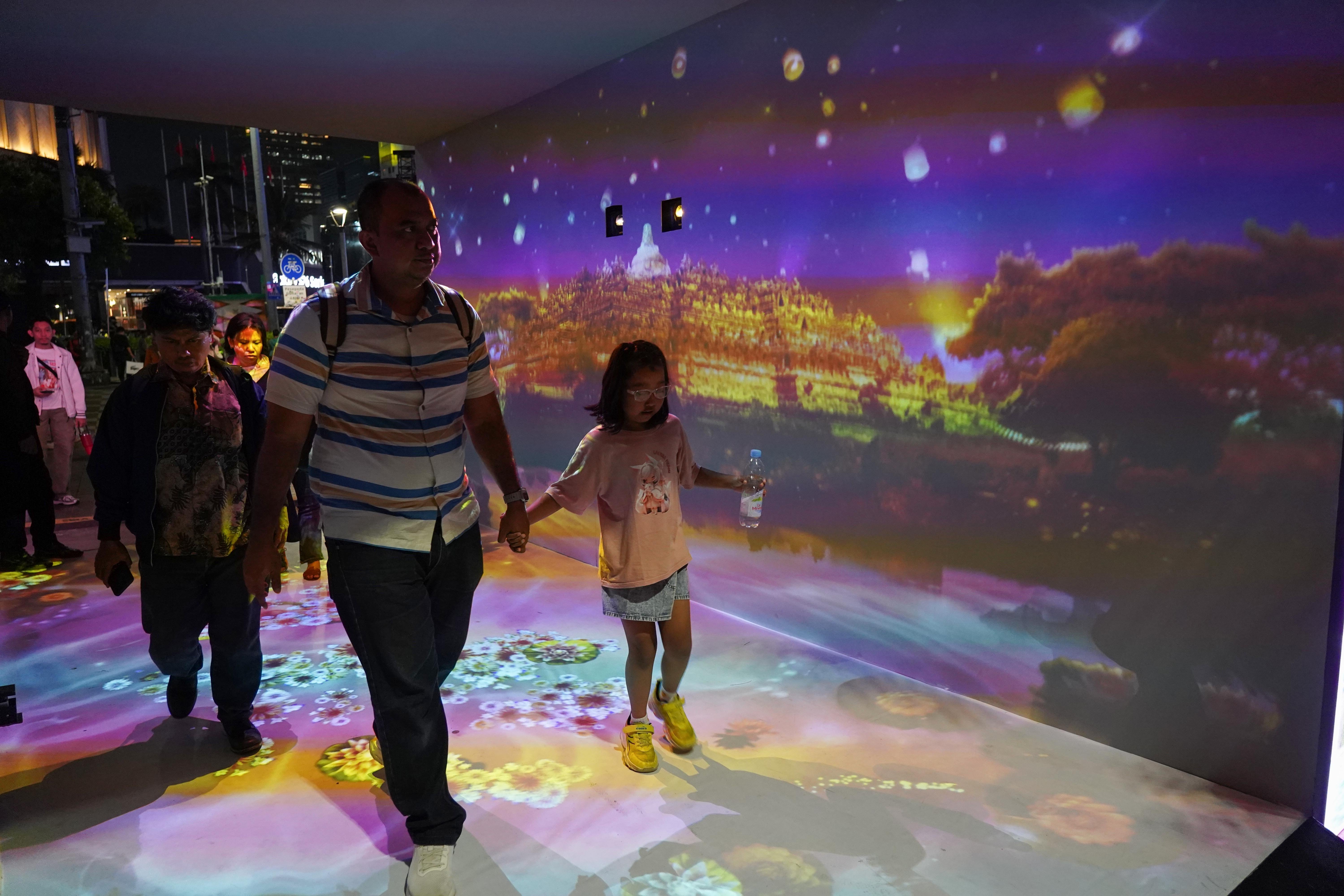 Sejumlah warga berjalan di instalasi cahaya dalam gelaran illumination of Jakarta: Glow of Peace di kawasan Bundaran HI, Jakarta, Jumat (29/5/2026).Acara yang digelar Pemprov DKI Jakarta untuk menyambut Hari Raya Waisak 2570 BE ini menghadirkan ornamen lampu hias, pertunjukan budaya, serta doa dan renungan bersama sebagai wujud refleksi dan pesan perdamaian, serta berlangsung hingga 1 Juni 2026.