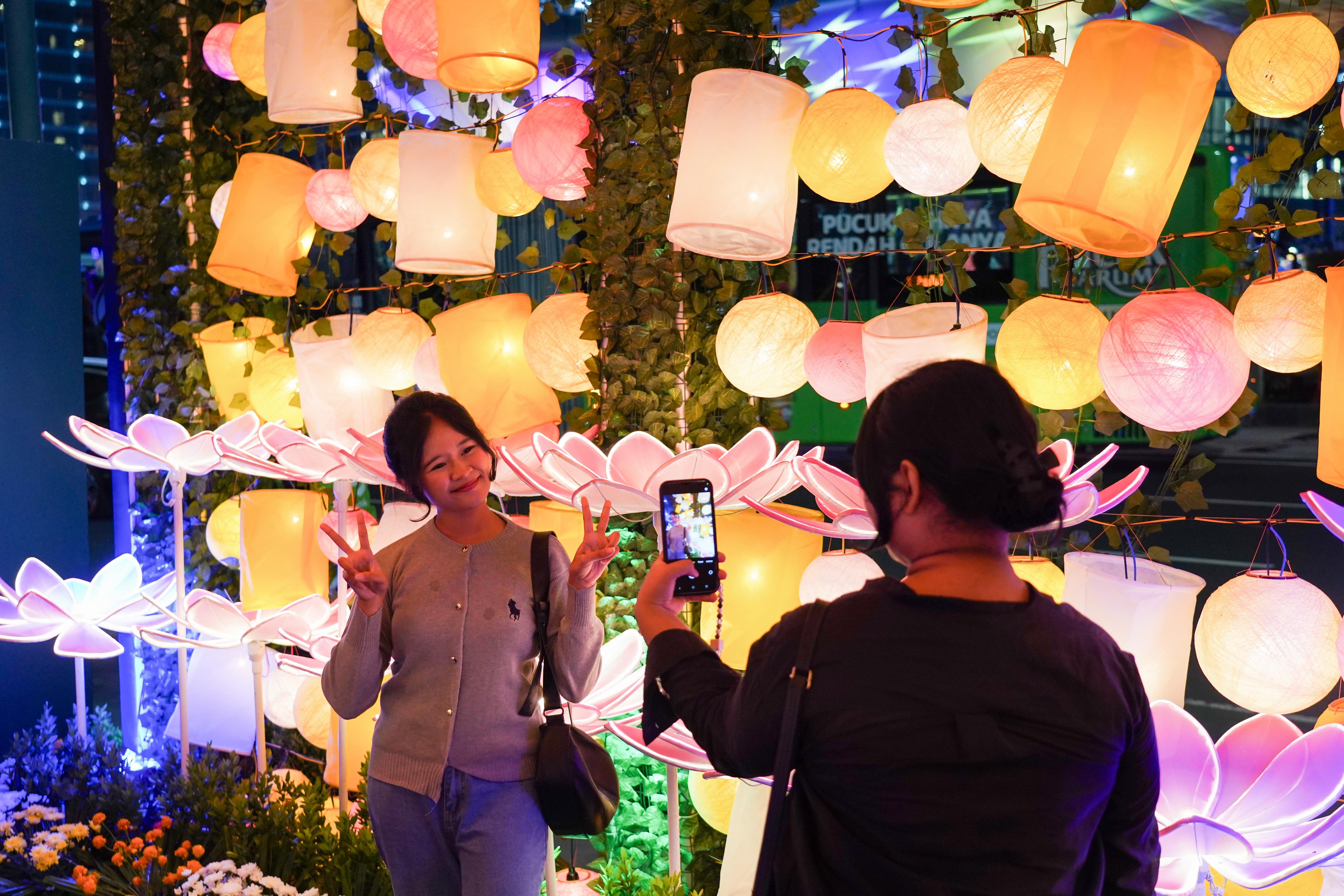 Warga berfoto di instalasi cahaya dalam gelaran Illumination of Jakarta: Glow of Peace di kawasan Bundaran HI, Jakarta, Jumat (29/5/2026). Acara yang digelar Pemprov DKI Jakarta untuk menyambut Hari Raya Waisak 2570 BE ini menghadirkan ornamen lampu hias, pertunjukan budaya, serta doa dan renungan bersama sebagai wujud refleksi dan pesan perdamaian, serta berlangsung hingga 1 Juni 2026.