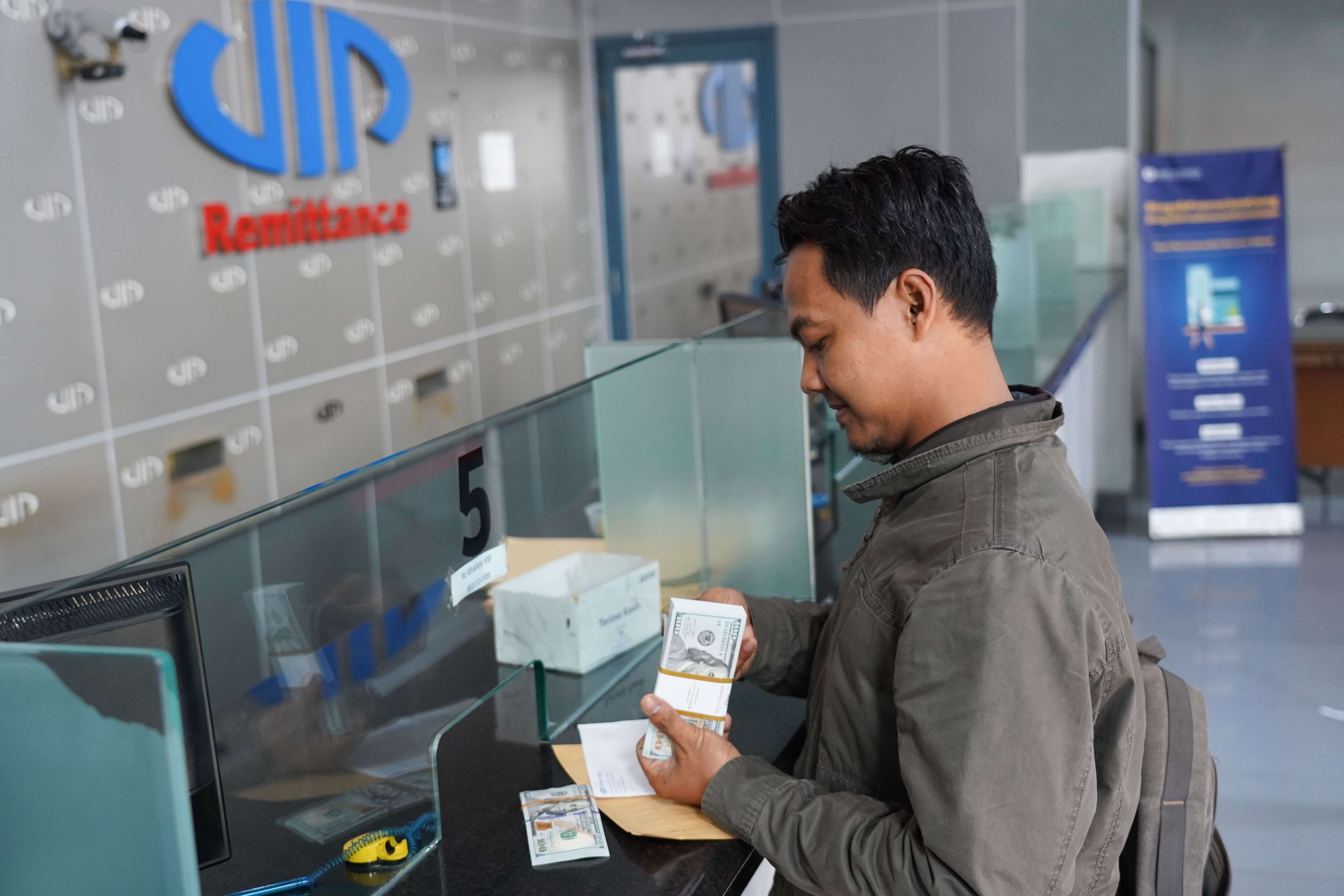 Warga menghitung pecahan mata uang dolar Amerika Serikat (AS) setelah menukarkan uangnya di gerai penukaran uang asing di Jakarta, Kamis (4/6/2026). Nilai tukar rupiah rupiah terhadap dolar AS ditutup melemah 0,46 persen menjadi Rp18.049 per dolar AS dari sebelumnya Rp17.966 per dolar AS.