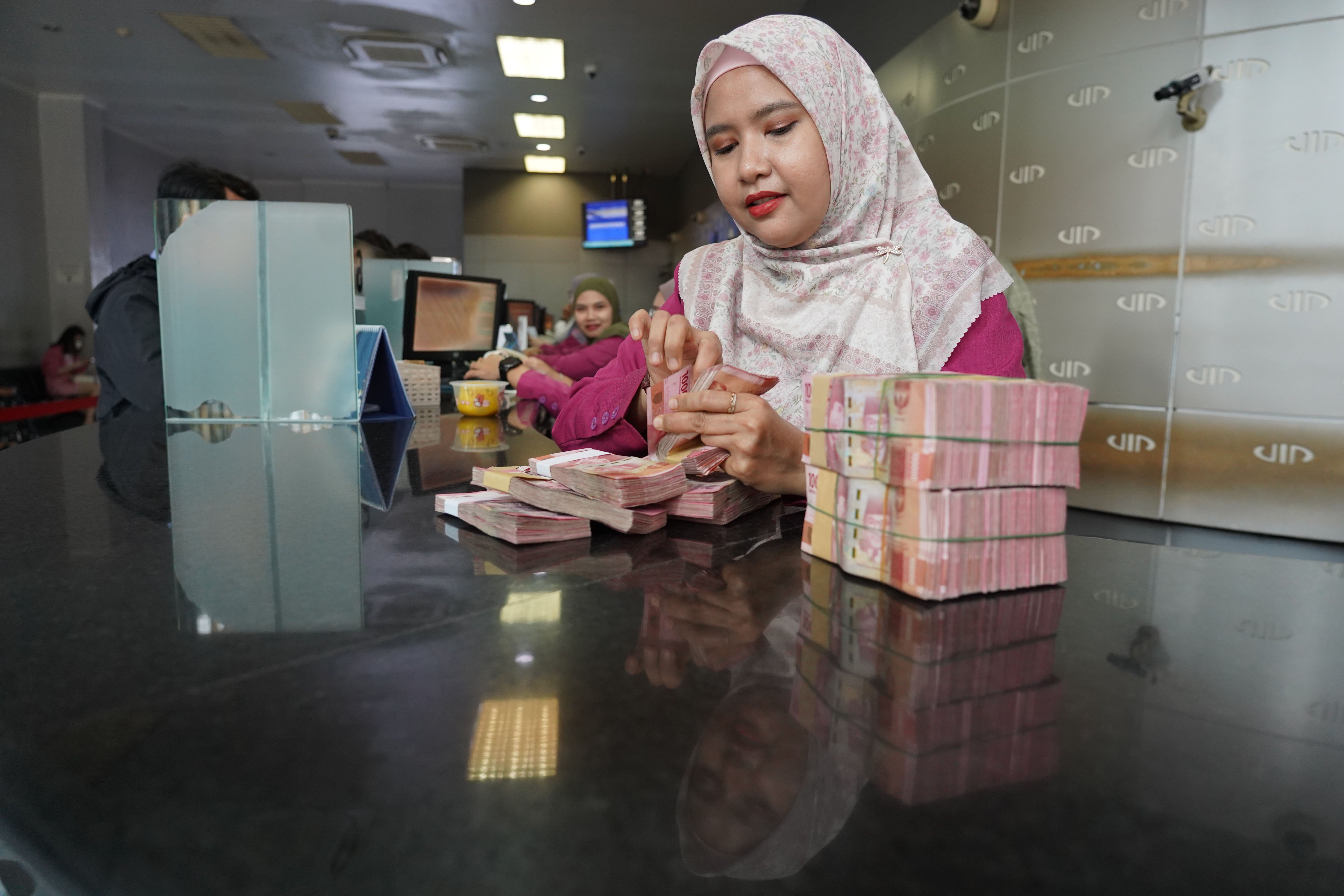 Petugas menghitung uang rupiah di gerai penukaran uang asing di Jakarta, Kamis (4/6/2026). Nilai tukar rupiah rupiah terhadap dolar AS ditutup melemah 0,46 persen menjadi Rp18.049 per dolar AS dari sebelumnya Rp17.966 per dolar AS.
