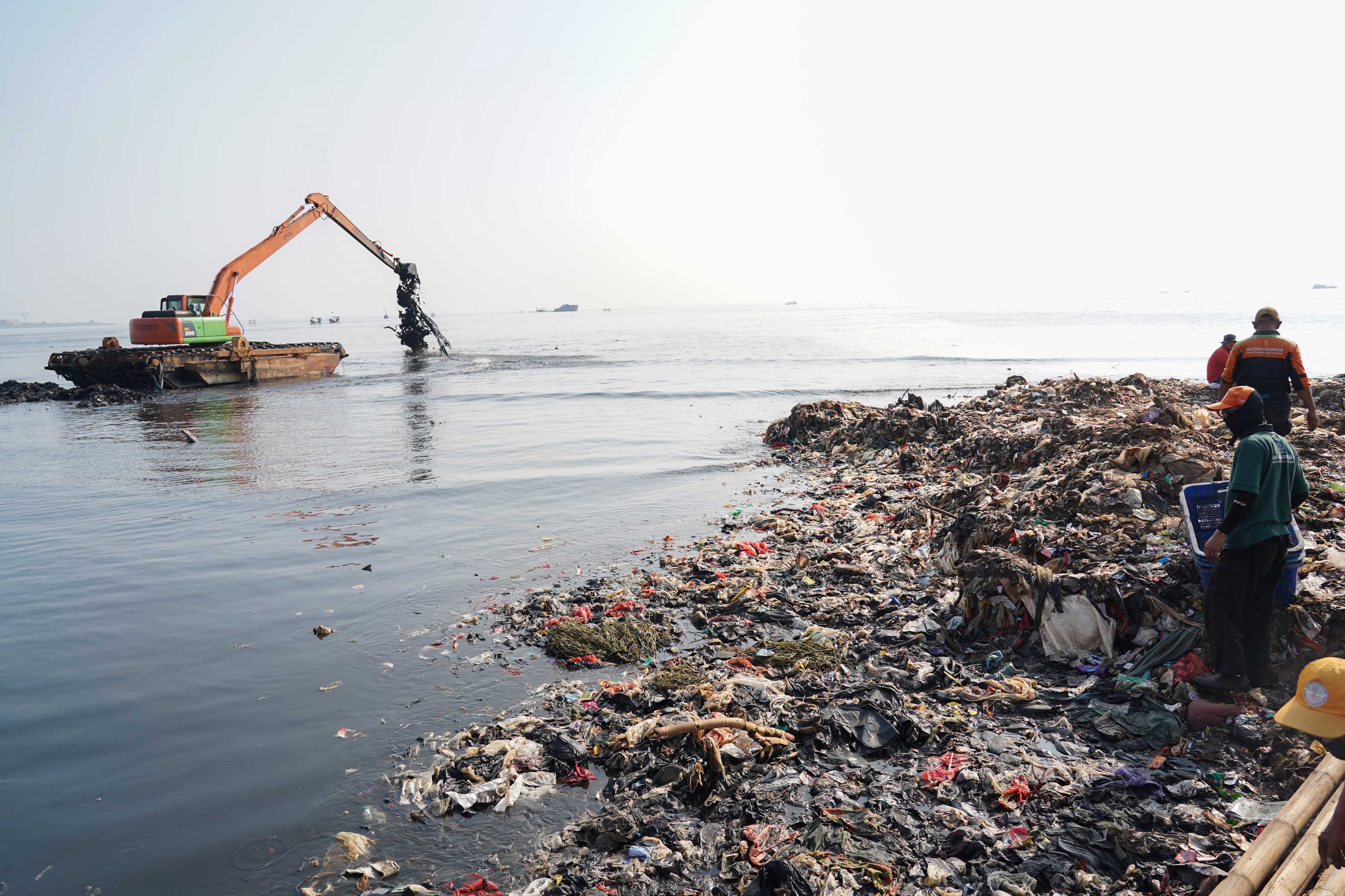 Petugas Suku Dinas Lingkungan Hidup Jakarta Utara mengangkut sampah yang menumpuk di pesisir laut kawasan Muara Angke, Jakarta Utara, Senin (8/6/2026). Pembersihan tersebut dilakukan guna menagani sampah agar tidak mencemari lingkungan laut dan kawasan di sekitarnya serta menggangu aktivitas nelayan.
