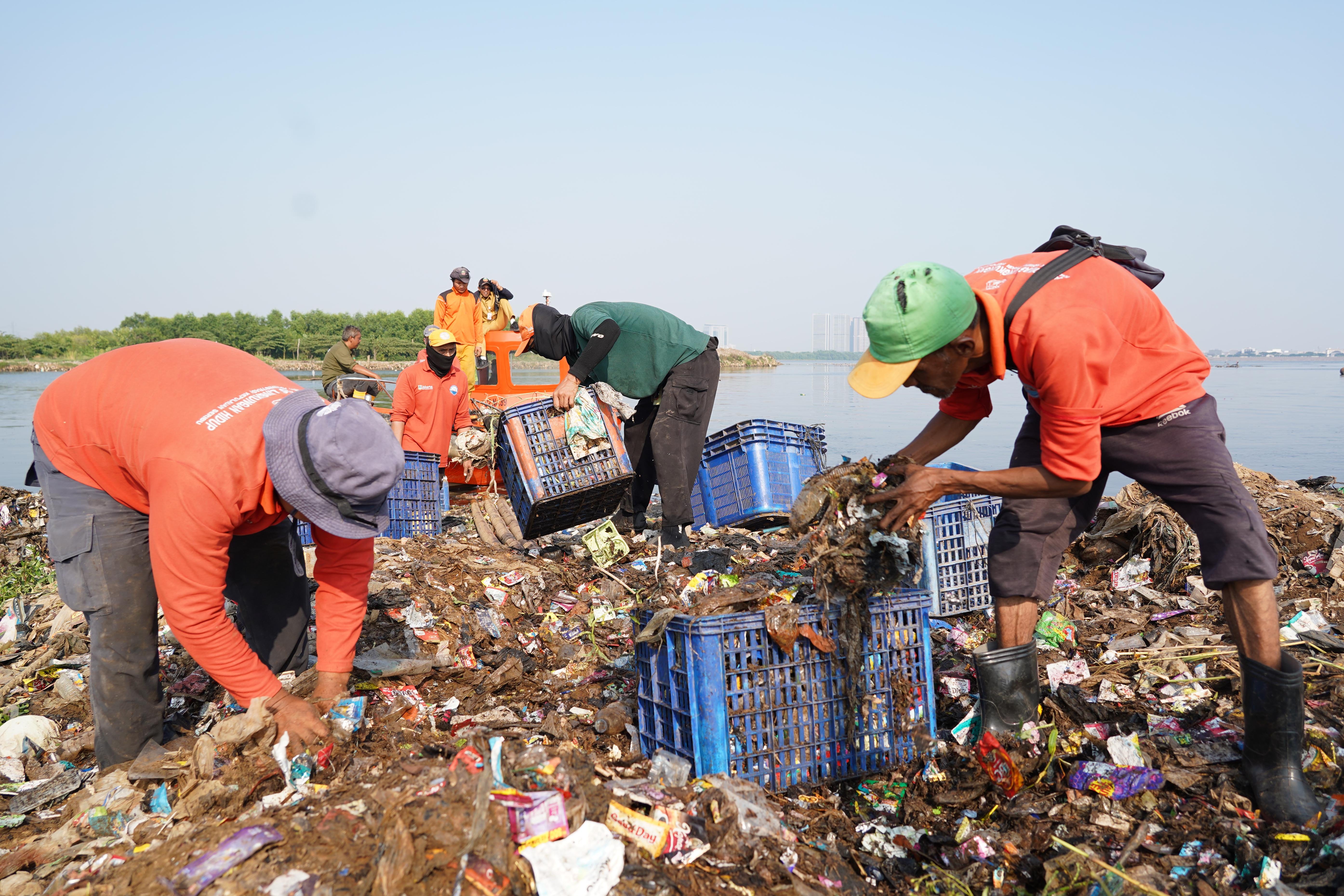 Petugas Suku Dinas Lingkungan Hidup Jakarta Utara mengangkut sampah yang menumpuk di pesisir laut kawasan Muara Angke, Jakarta Utara, Senin (8/6/2026). Pembersihan tersebut dilakukan guna menagani sampah agar tidak mencemari lingkungan laut dan kawasan di sekitarnya serta menggangu aktivitas nelayan.