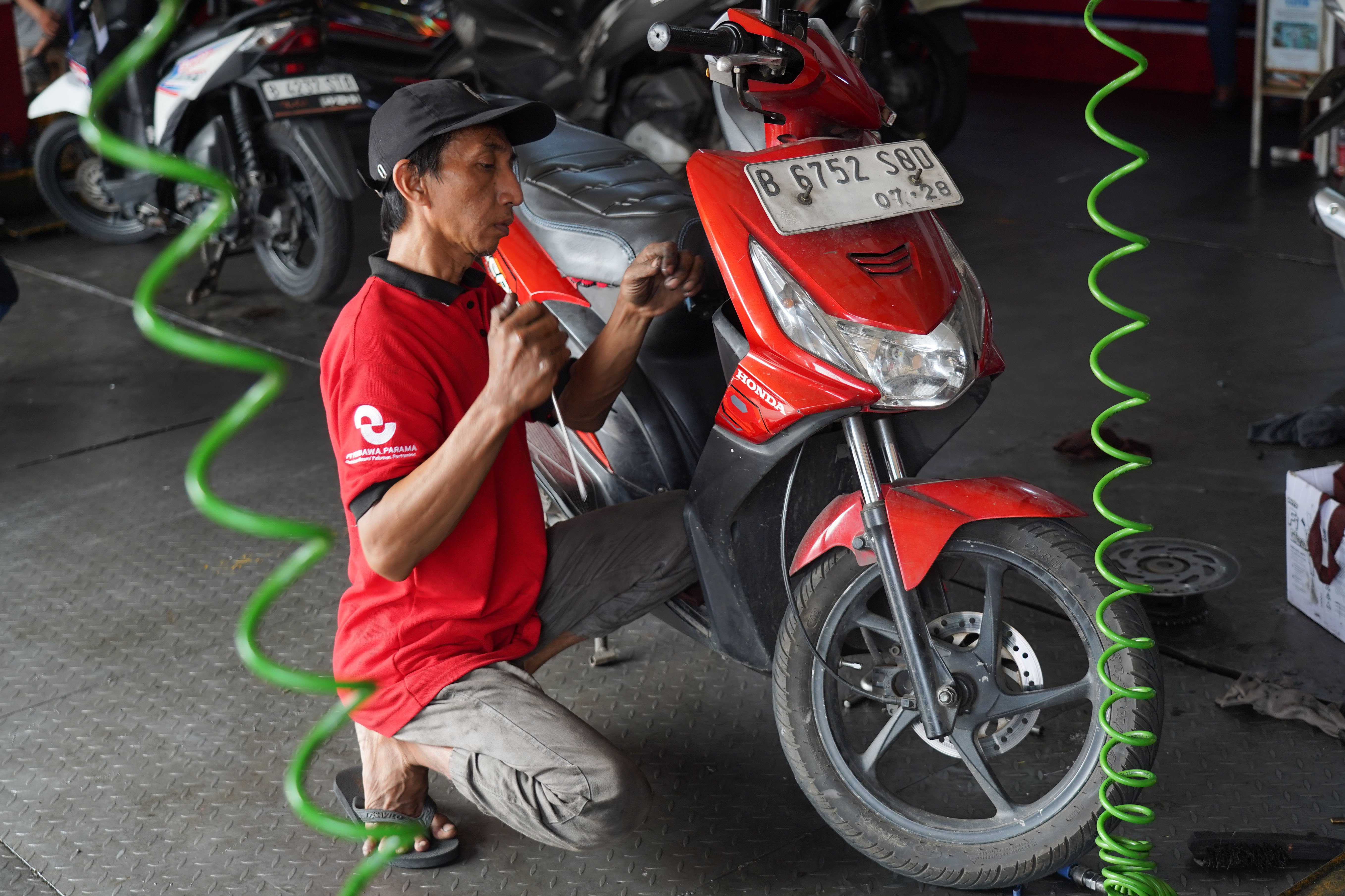 Mekanik menuangkan oli sepeda motor di salah satu bengkel di kawasan Pasar Minggu, Jakarta, Selasa (9/6/2026). Melemahnya nilai tukar rupiah terhadap dolar Amerika membuat harga onderdil motor seperti oli, ban hingga kampas rem mengalami kenaikan harga rata-rata dari Rp 15 ribu hingga Rp 20 ribu.