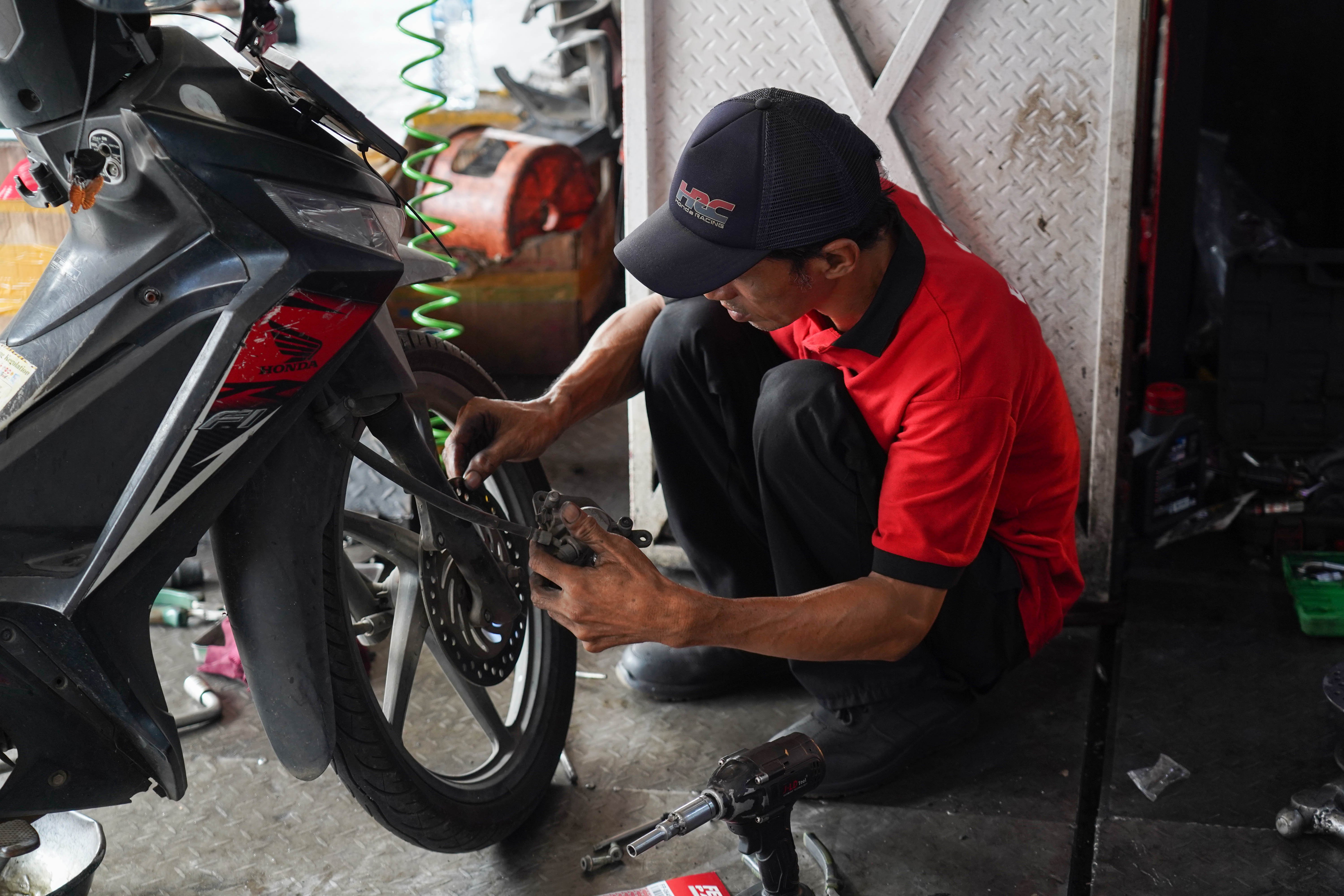 Mekanik menuangkan oli sepeda motor di salah satu bengkel di kawasan Pasar Minggu, Jakarta, Selasa (9/6/2026). Melemahnya nilai tukar rupiah terhadap dolar Amerika membuat harga onderdil motor seperti oli, ban hingga kampas rem mengalami kenaikan harga rata-rata dari Rp 15 ribu hingga Rp 20 ribu.