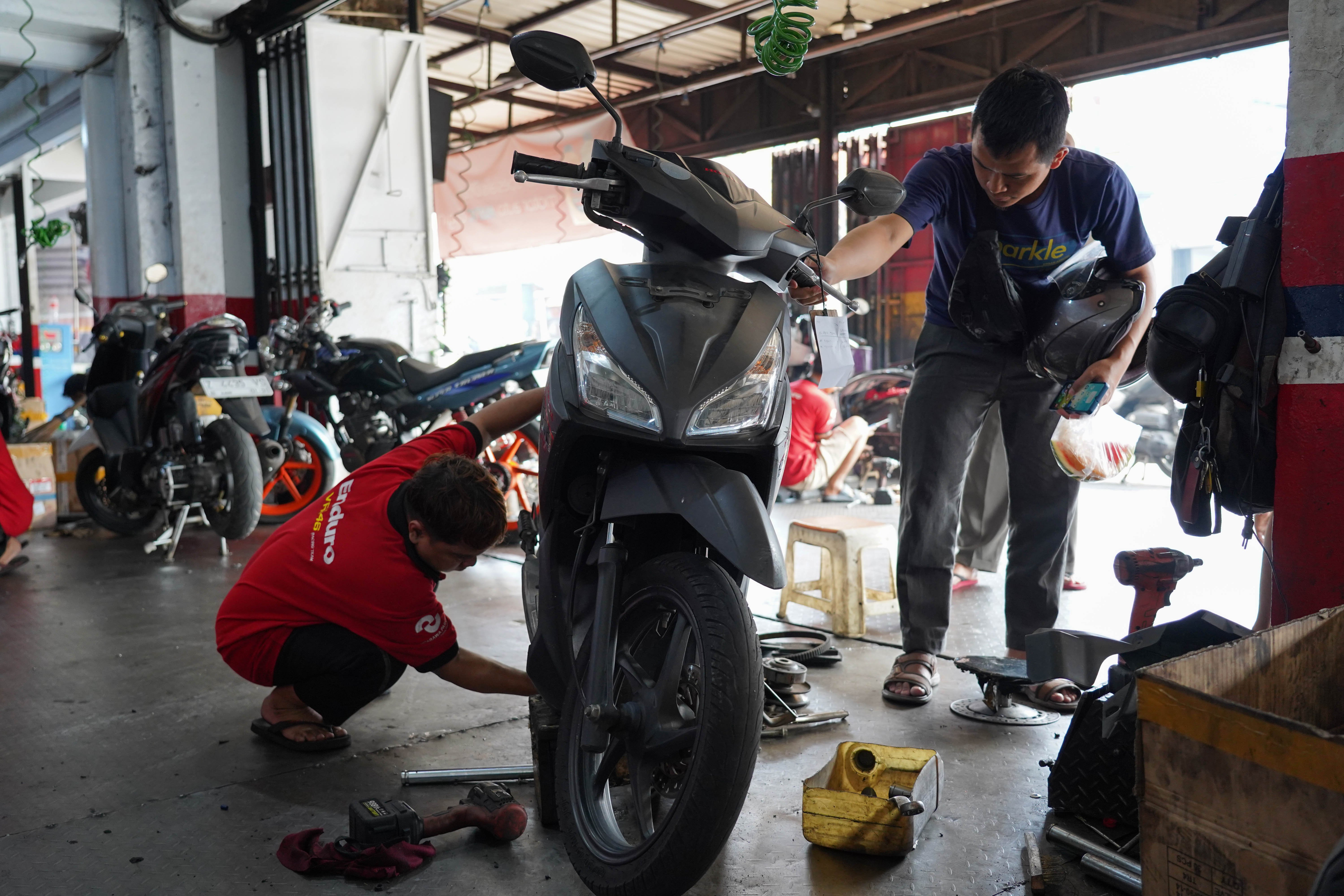 Warga melihat motornya yang sedang diperbaiki di salah satu bengkel di kawasan Pasar Minggu, Jakarta, Selasa (9/6/2026). Melemahnya nilai tukar rupiah terhadap dolar Amerika membuat harga onderdil motor seperti oli, ban hingga kampas rem mengalami kenaikan harga rata-rata dari Rp 15 ribu hingga Rp 20 ribu.