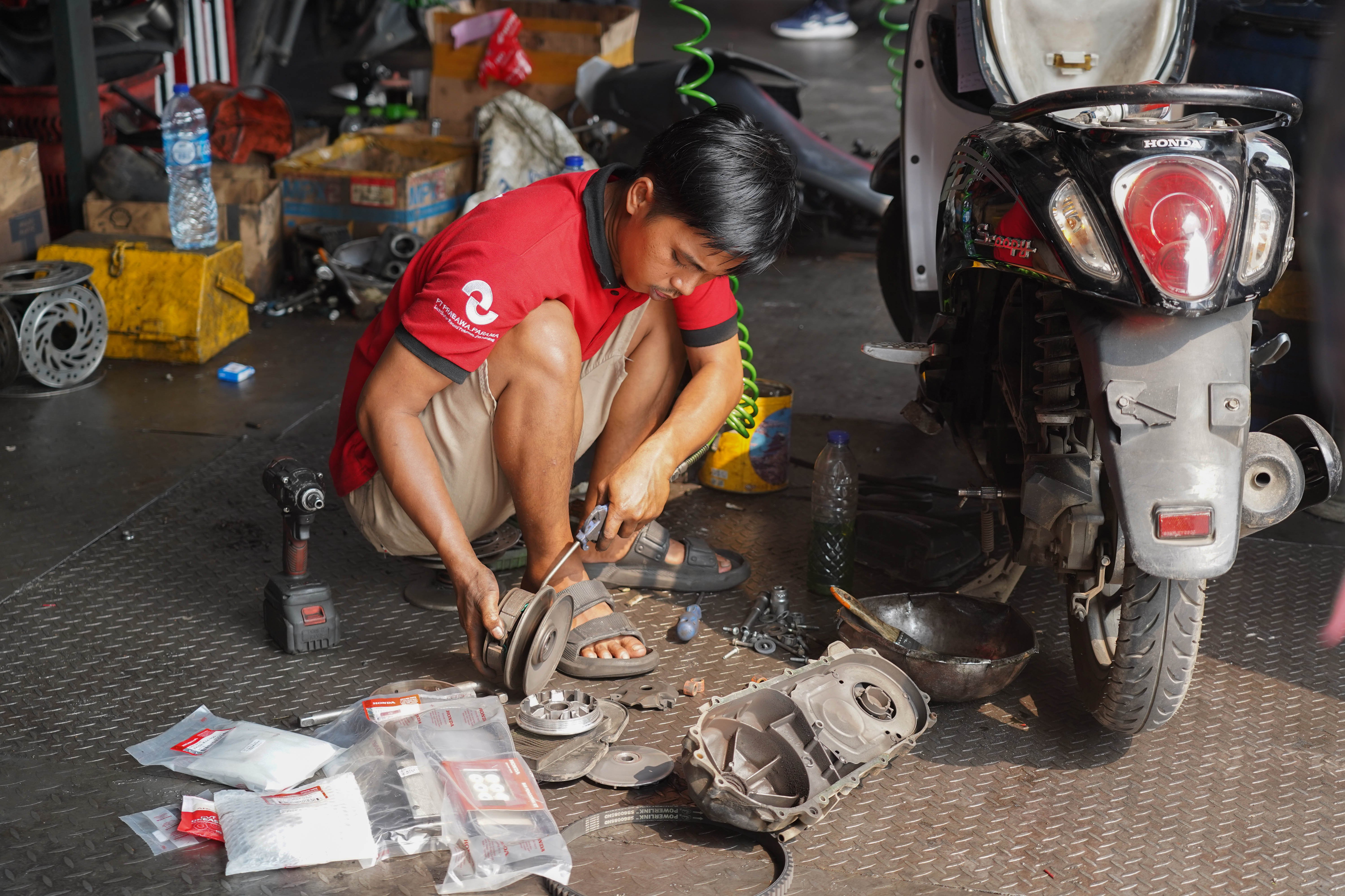 Mekanik memperbaiki sepeda motor di salah satu bengkel di kawasan Pasar Minggu, Jakarta, Selasa (9/6/2026). Melemahnya nilai tukar rupiah terhadap dolar Amerika membuat harga onderdil motor seperti oli, ban hingga kampas rem mengalami kenaikan harga rata-rata dari Rp 15 ribu hingga Rp 20 ribu.