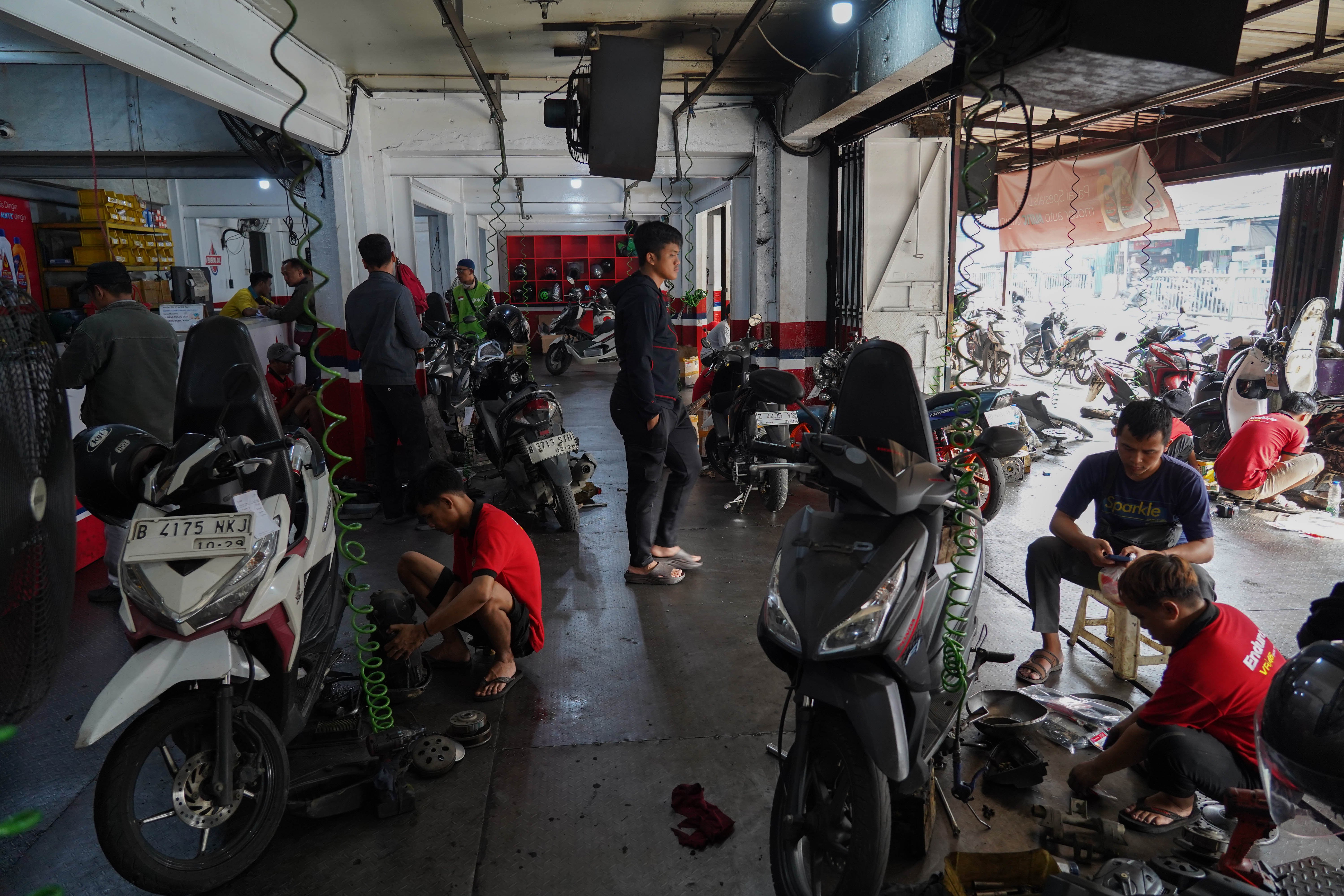 Mekanik memperbaiki sepeda motor di salah satu bengkel di kawasan Pasar Minggu, Jakarta, Selasa (9/6/2026). Melemahnya nilai tukar rupiah terhadap dolar Amerika membuat harga onderdil motor seperti oli, ban hingga kampas rem mengalami kenaikan harga rata-rata dari Rp 15 ribu hingga Rp 20 ribu.