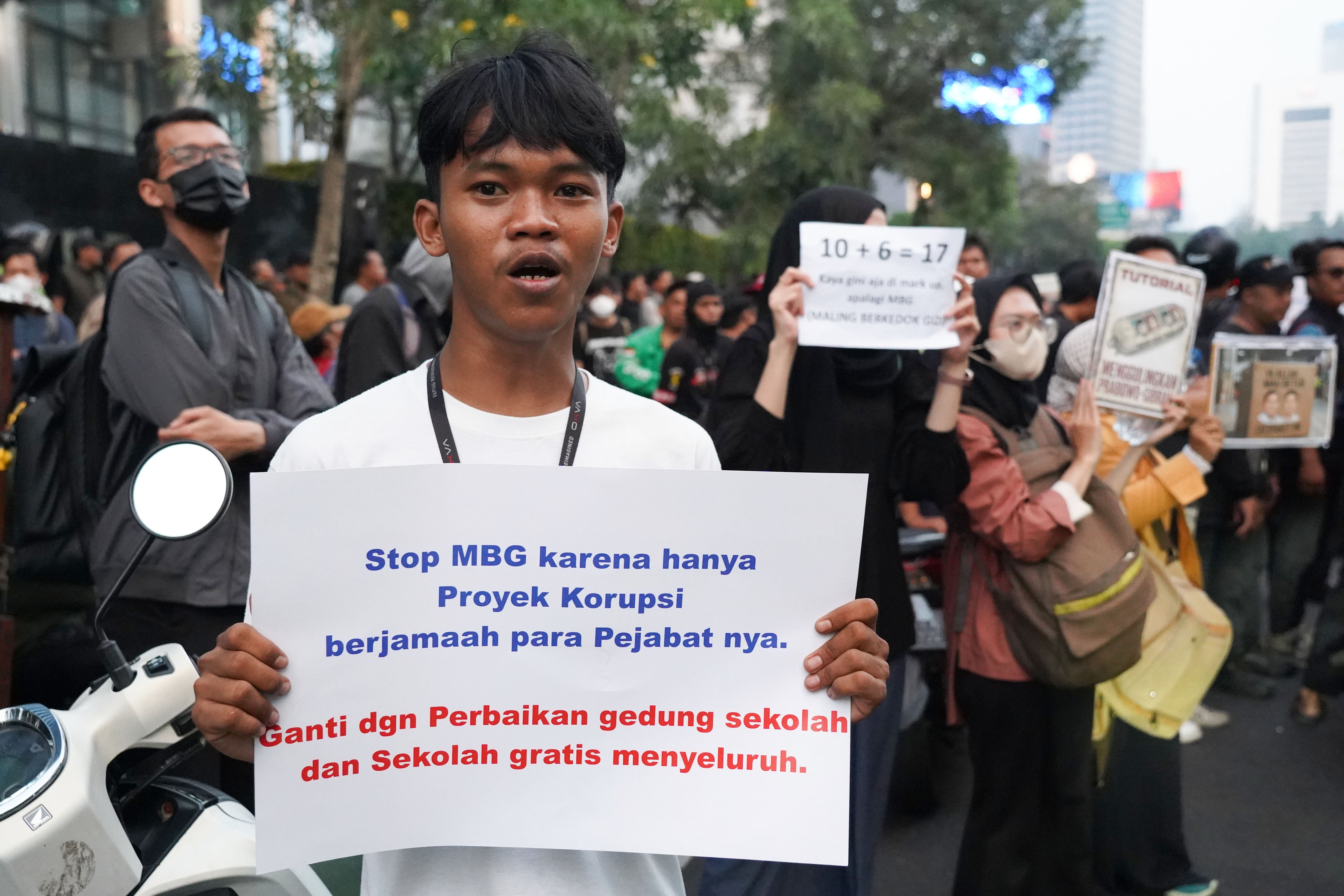 Warga membawa poster tuntutan saat berdemonstrasi bersama mahasiswa di kawasan Jalan MH Thamrin, Jakarta Pusat, Jumat (12/6/2026). Dalam aksi tersebut mereka menyampaikan tuntutan kepada pemerintah diantaranya hentikan pemborosan APBN dengan menyetop program Makan Bergizi Gratis (MBG) karena dinilai tidak efektif serta turunkan harga kebutuhan pokok dan bahan bakar minyak (BBM) yang membebani masyarakat.