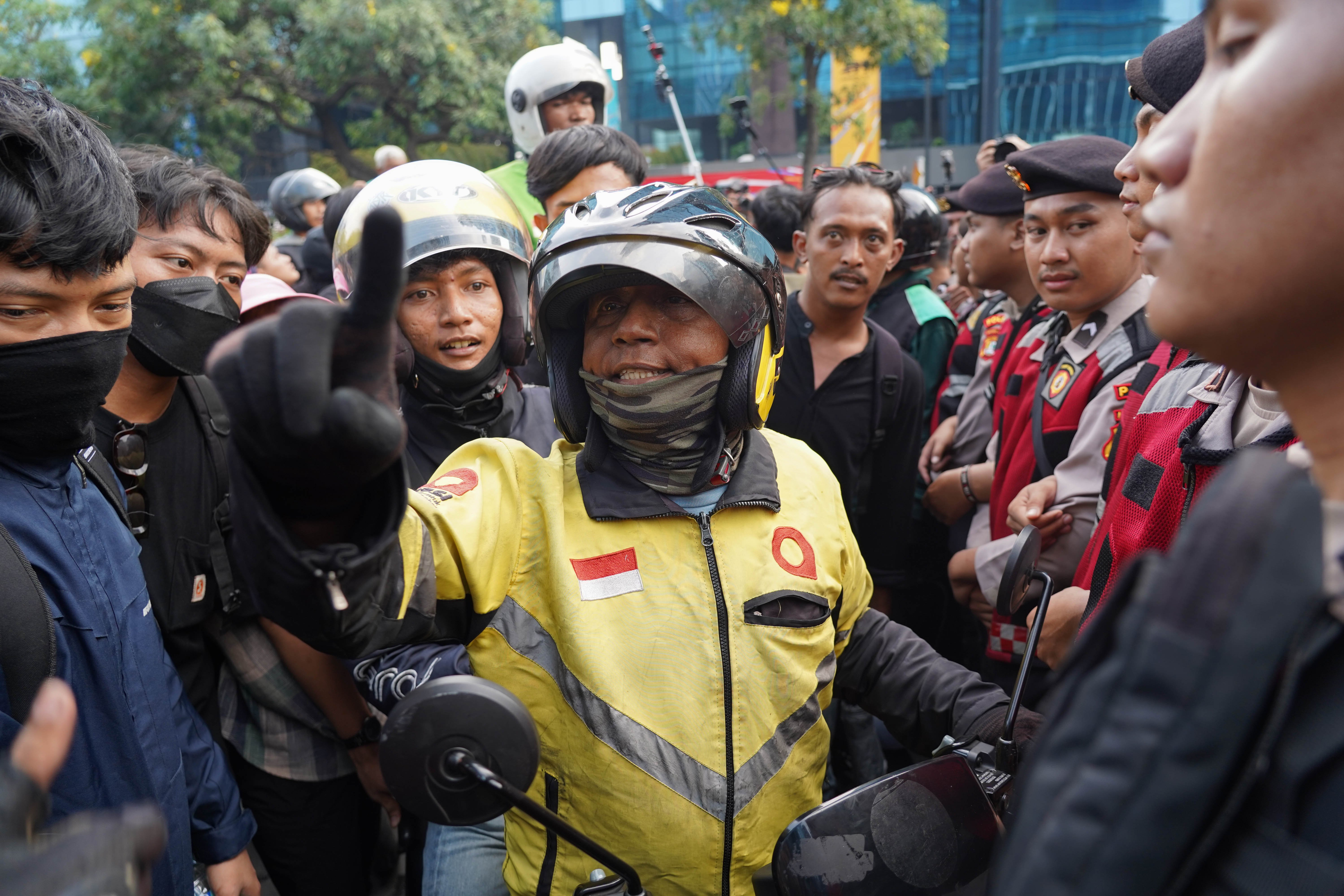 Pengemudi ojek daring bersitegang dengan personel kepolisian saat mencoba melewati barikade yang menjaga aksi demo mahasiswa di kawasan Jalan MH Thamrin, Jakarta Pusat, Jumat (12/6/2026). Dalam aksi tersebut mereka menyampaikan tuntutan kepada pemerintah diantaranya hentikan pemborosan APBN dengan menyetop program Makan Bergizi Gratis (MBG) karena dinilai tidak efektif serta turunkan harga kebutuhan pokok dan bahan bakar minyak (BBM) yang membebani masyarakat.