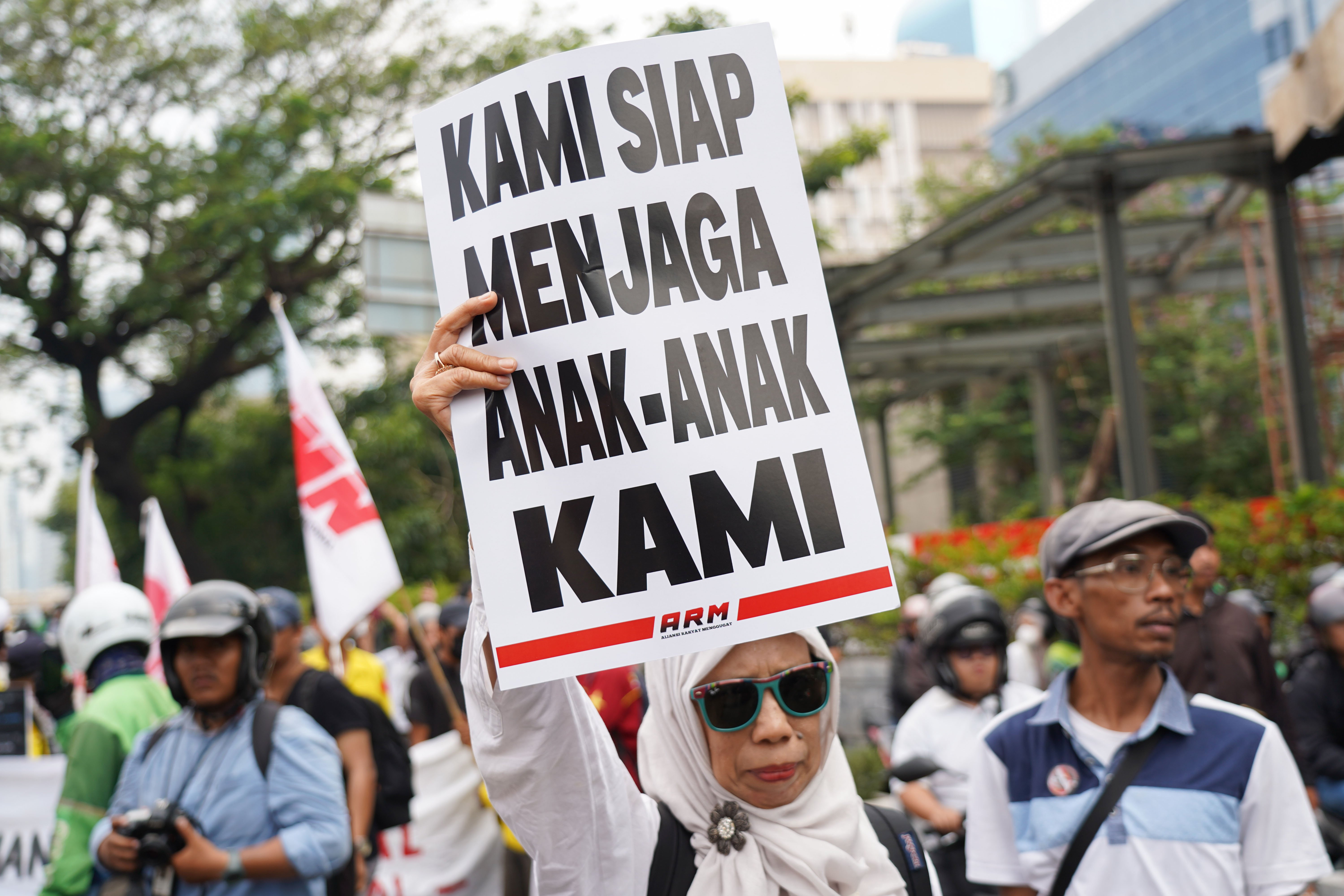 Warga membawa poster tuntutan saat berdemonstrasi bersama mahasiswa di kawasan Jalan MH Thamrin, Jakarta Pusat, Jumat (12/6/2026). Dalam aksi tersebut mereka menyampaikan tuntutan kepada pemerintah diantaranya hentikan pemborosan APBN dengan menyetop program Makan Bergizi Gratis (MBG) karena dinilai tidak efektif serta turunkan harga kebutuhan pokok dan bahan bakar minyak (BBM) yang membebani masyarakat.