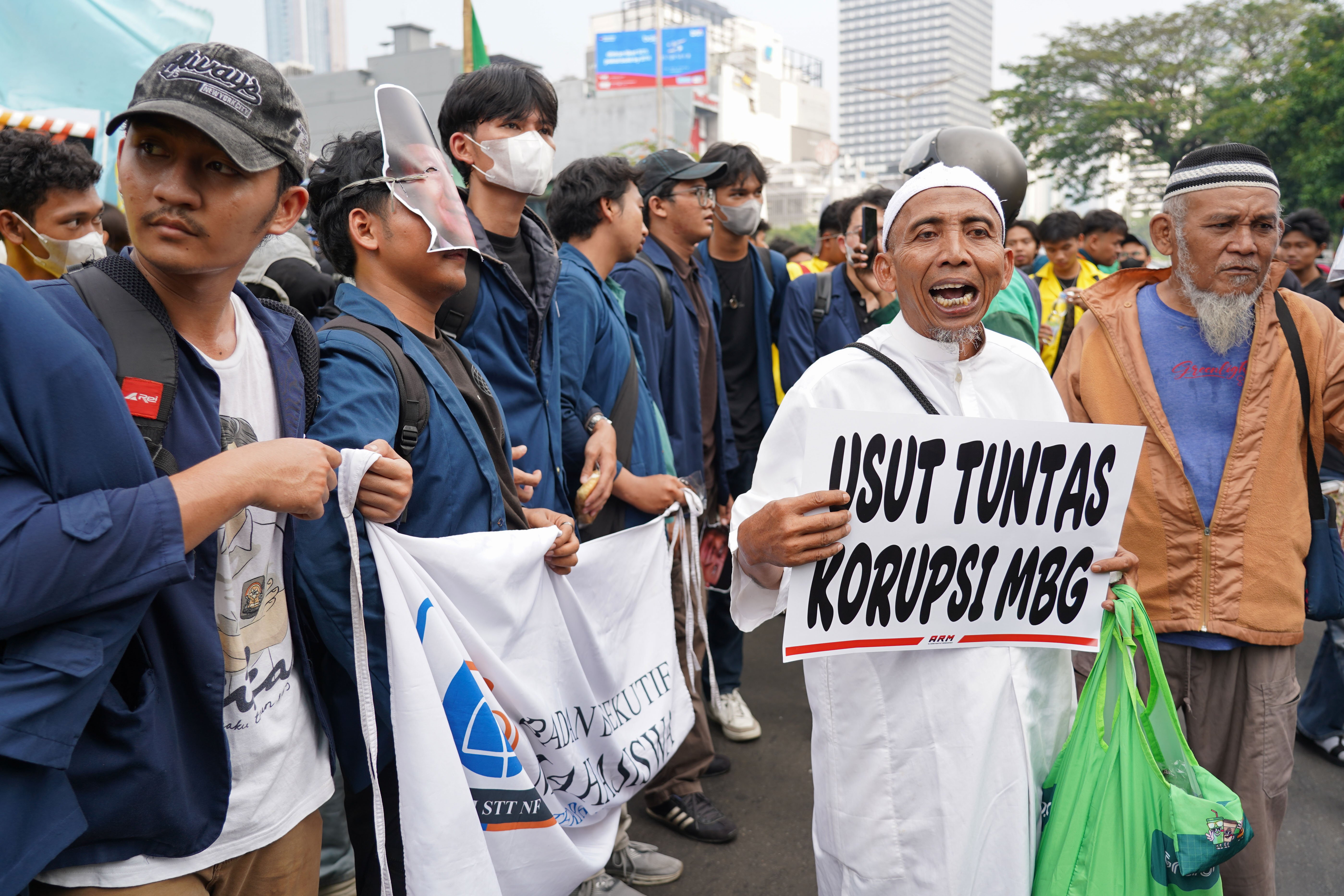 Warga membawa poster tuntutan saat berdemonstrasi bersama mahasiswa di kawasan Jalan MH Thamrin, Jakarta Pusat, Jumat (12/6/2026). Dalam aksi tersebut mereka menyampaikan tuntutan kepada pemerintah diantaranya hentikan pemborosan APBN dengan menyetop program Makan Bergizi Gratis (MBG) karena dinilai tidak efektif serta turunkan harga kebutuhan pokok dan bahan bakar minyak (BBM) yang membebani masyarakat.
