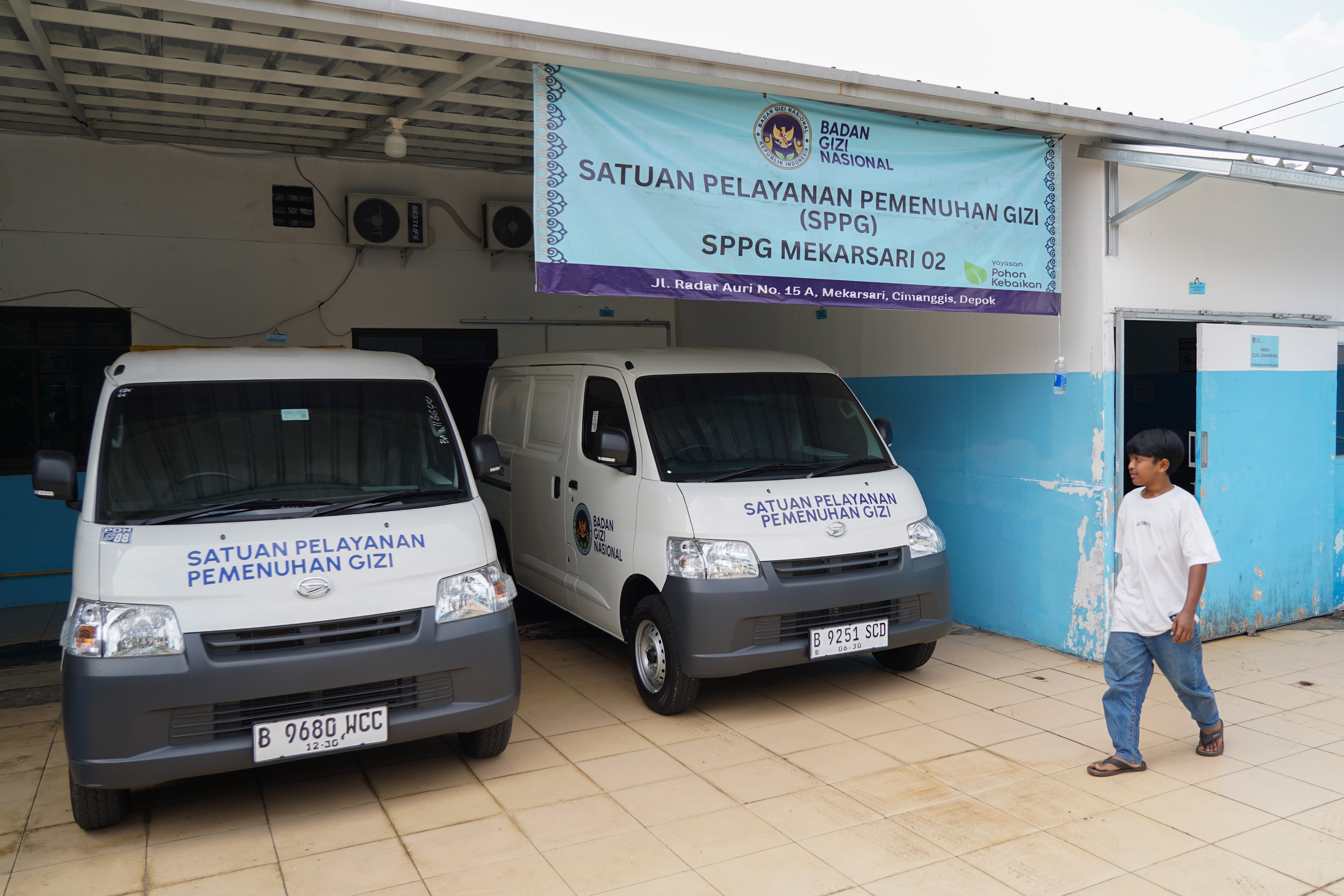 Petugas berjalan di dekat mobil pengantar Makan Bergizi Gratis (MBG) di Satuan Pelayanan Pemenuhan Gizi (SPPG) Mekarsari 02 saat operasionalnya berhenti sementara di kawasan Kecamatan Cimanggis, Depok, Jawa Barat, Kamis (11/6/2026). Berdasarkan keterangan Kepala SPPG, pemberhentian sementara tersebut dilakukan karena dana untuk memproduksi MBG dari Badan Gizi Nasional (BGN) belum cair.