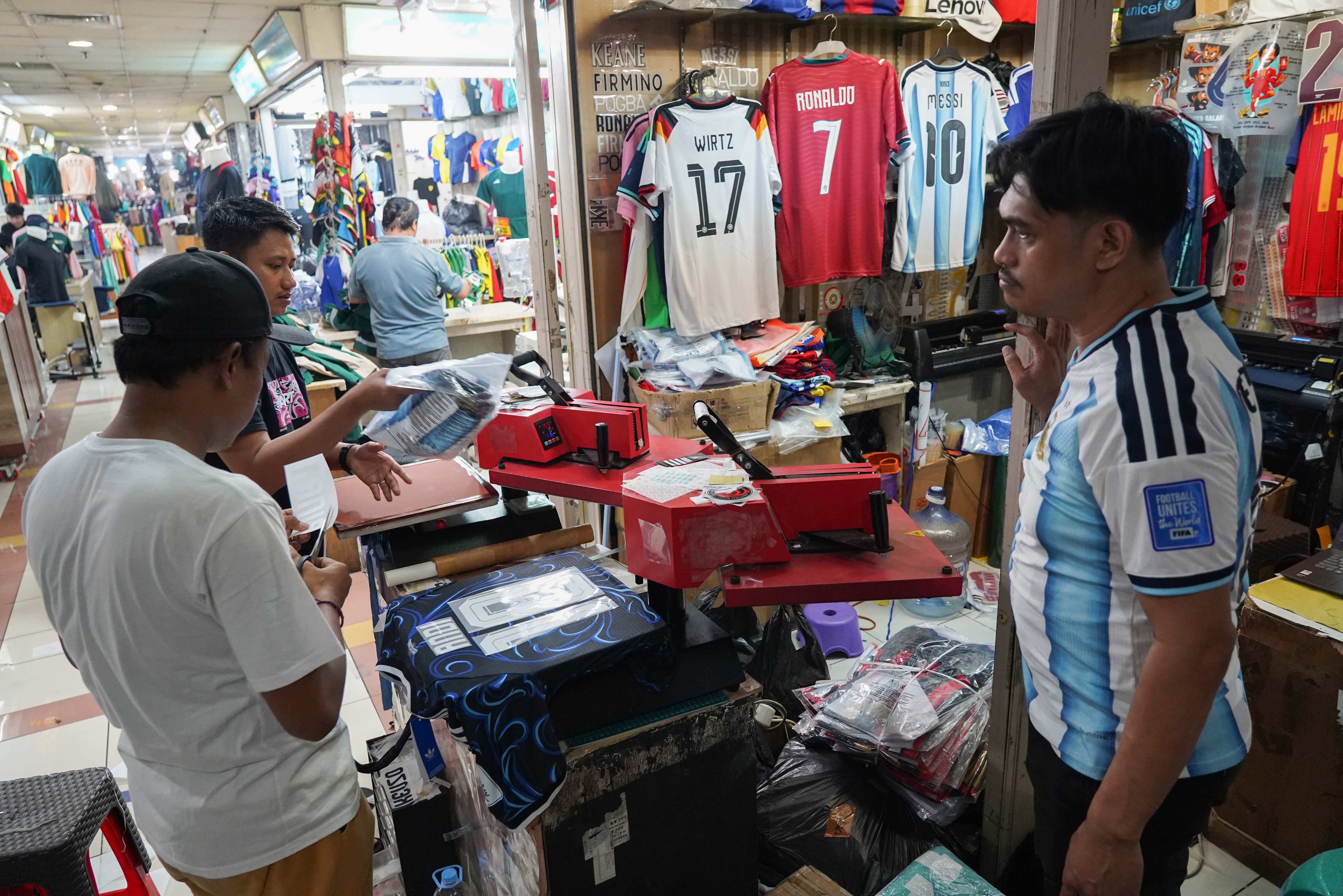 Pedagang menata nomor punggung pada kaos sepak bola di Pasar Tanah Abang Blok B, Jakarta, Rabu (17/6/2026). Berdasarkan keterangan pedagang, jersi negara peserta Piala Dunia yang dijajakan mulai dari Rp 220 ribu-Rp 270 ribu itu diminati oleh penggemar sepak bola sehingga penjualannya meningkat.