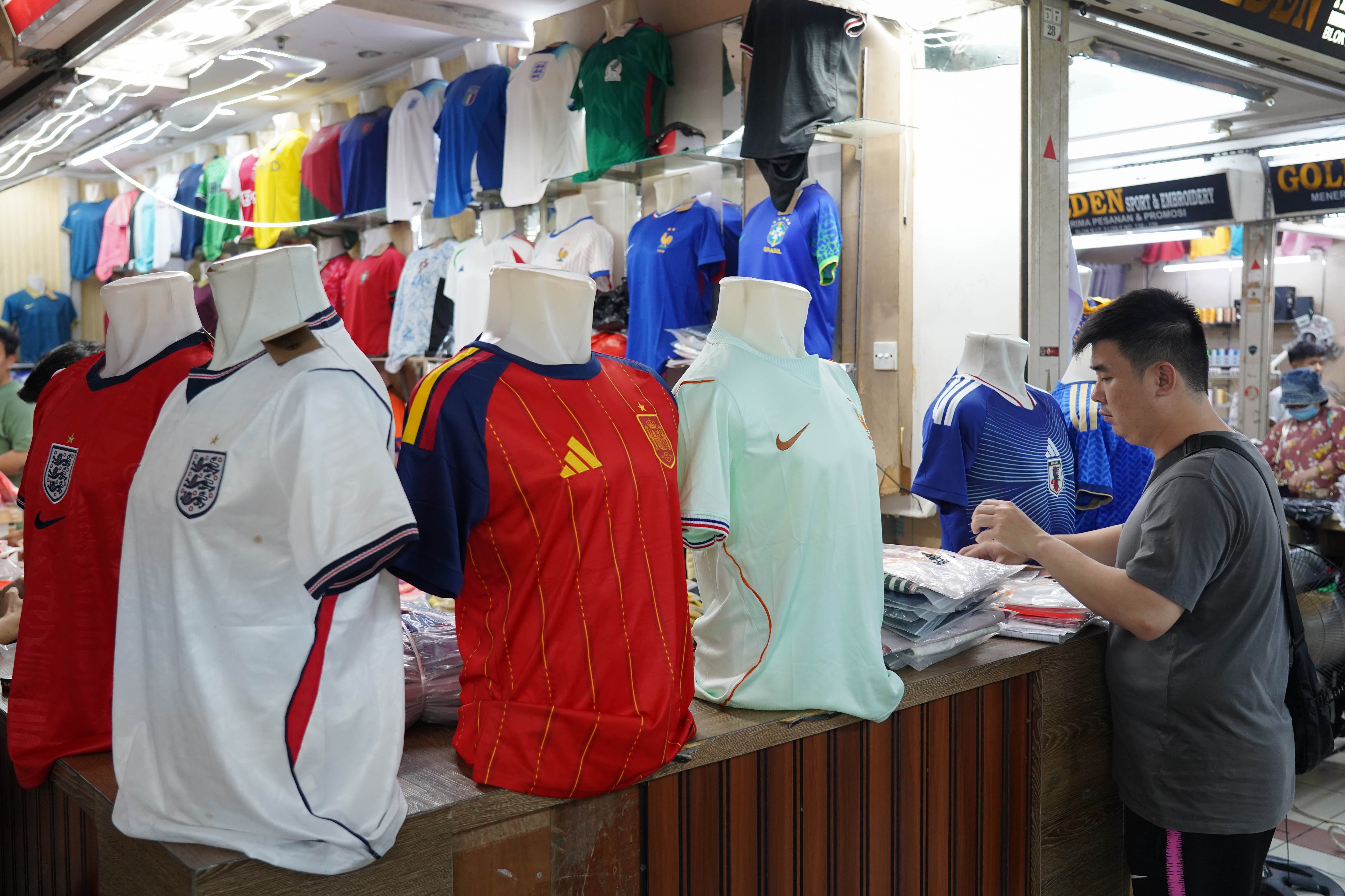 Calon pembeli melihat kaos sepak bola di Pasar Tanah Abang Blok B, Jakarta, Rabu (17/6/2026). Berdasarkan keterangan pedagang, jersi negara peserta Piala Dunia yang dijajakan mulai dari Rp 220 ribu-Rp 270 ribu itu diminati oleh penggemar sepak bola sehingga penjualannya meningkat.