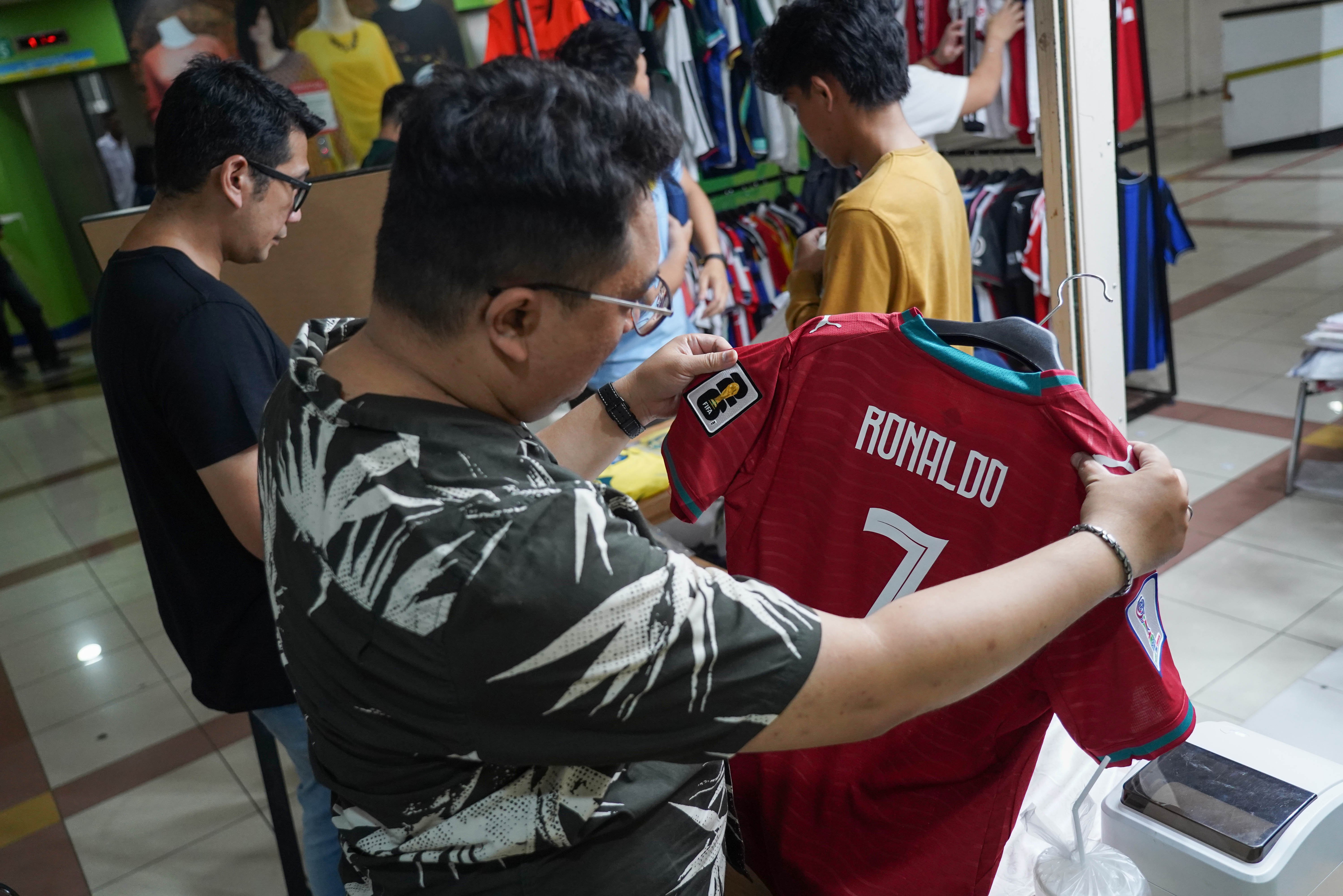 Calon pembeli melihat kaos sepak bola di Pasar Tanah Abang Blok B, Jakarta, Rabu (17/6/2026). Berdasarkan keterangan pedagang, jersi negara peserta Piala Dunia yang dijajakan mulai dari Rp 220 ribu-Rp 270 ribu itu diminati oleh penggemar sepak bola sehingga penjualannya meningkat.
