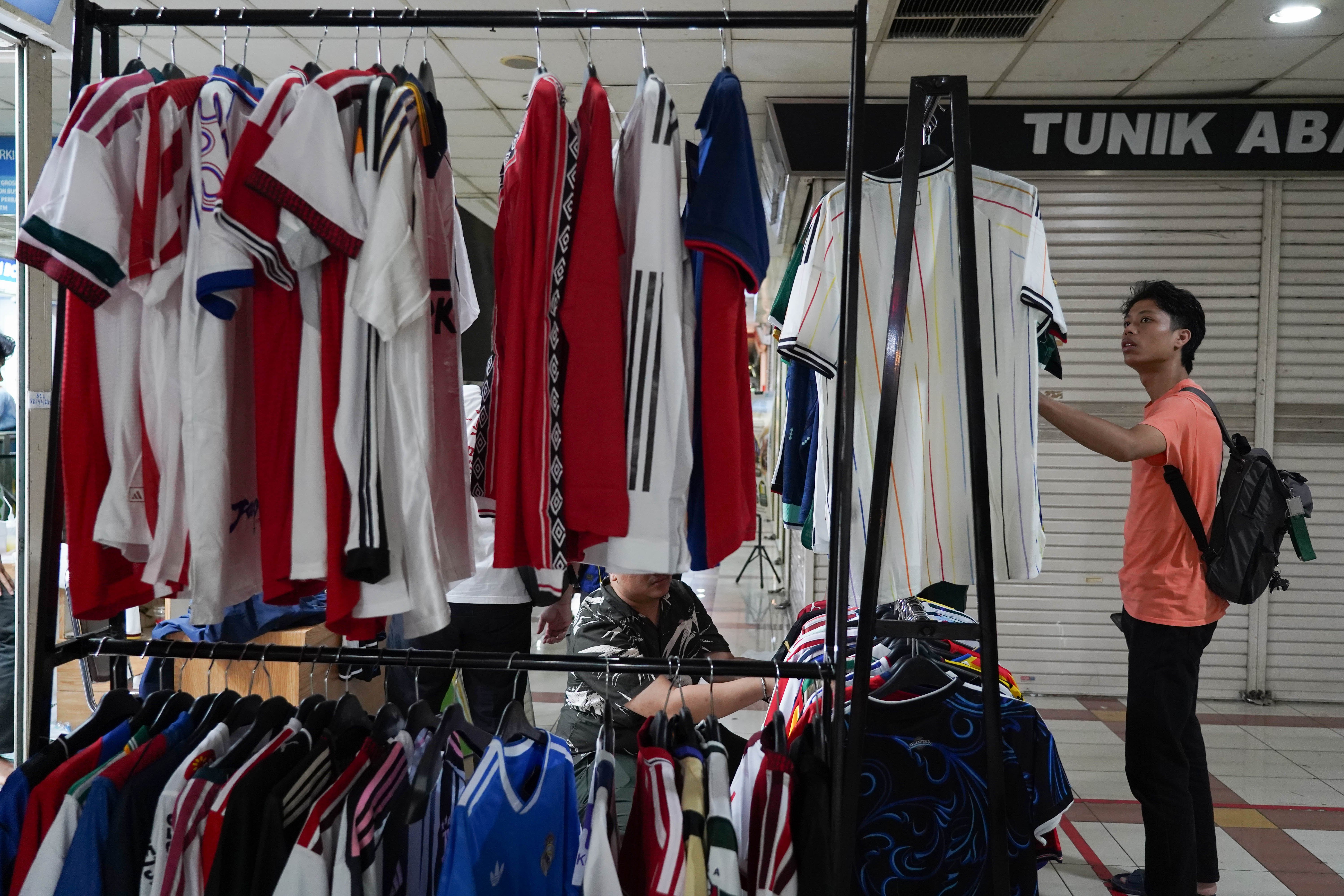 Calon pembeli melihat kaos sepak bola di Pasar Tanah Abang Blok B, Jakarta, Rabu (17/6/2026). Berdasarkan keterangan pedagang, jersi negara peserta Piala Dunia yang dijajakan mulai dari Rp 220 ribu-Rp 270 ribu itu diminati oleh penggemar sepak bola sehingga penjualannya meningkat.
