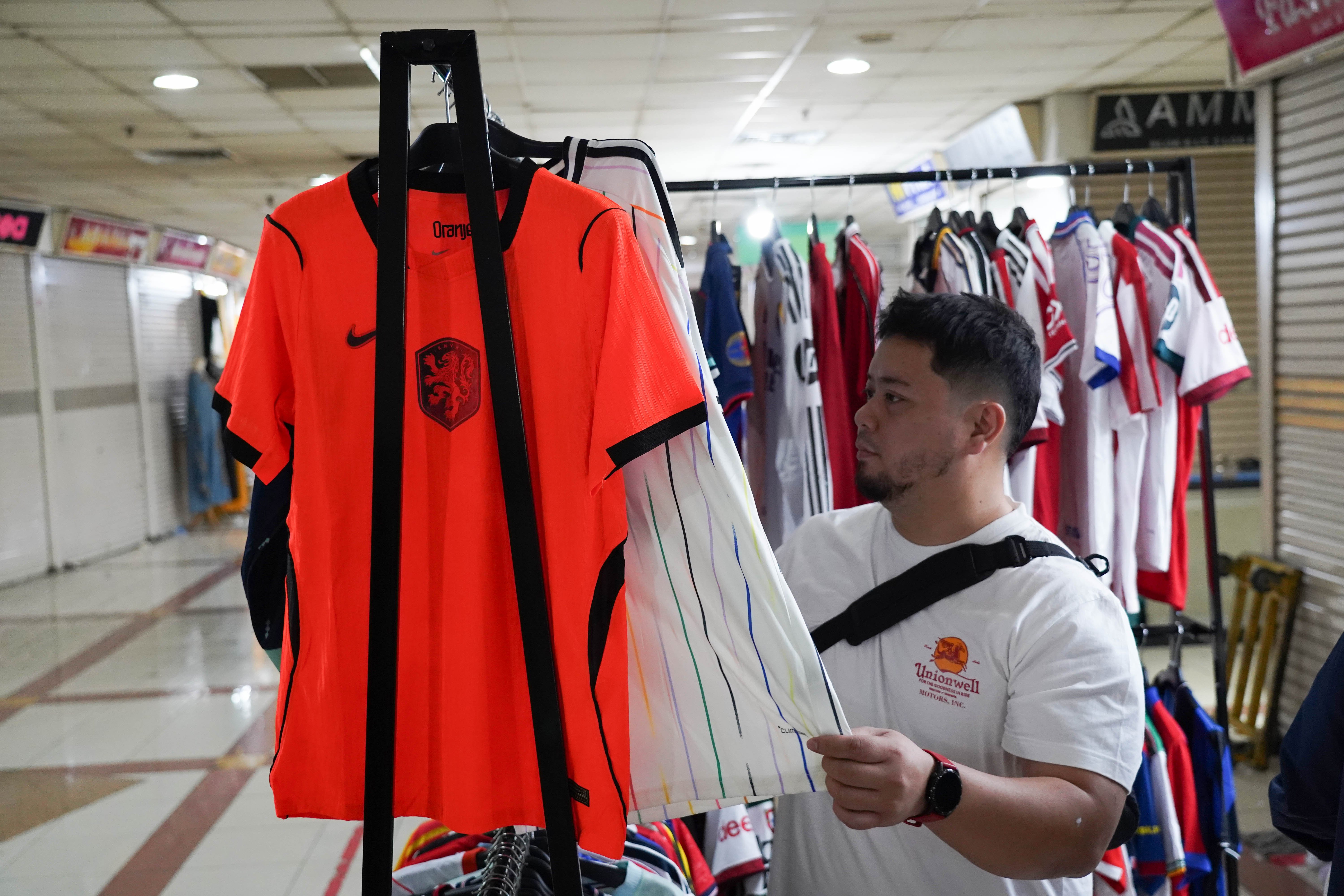 Calon pembeli melihat kaos sepak bola di Pasar Tanah Abang Blok B, Jakarta, Rabu (17/6/2026). Berdasarkan keterangan pedagang, jersi negara peserta Piala Dunia yang dijajakan mulai dari Rp 220 ribu-Rp 270 ribu itu diminati oleh penggemar sepak bola sehingga penjualannya meningkat.