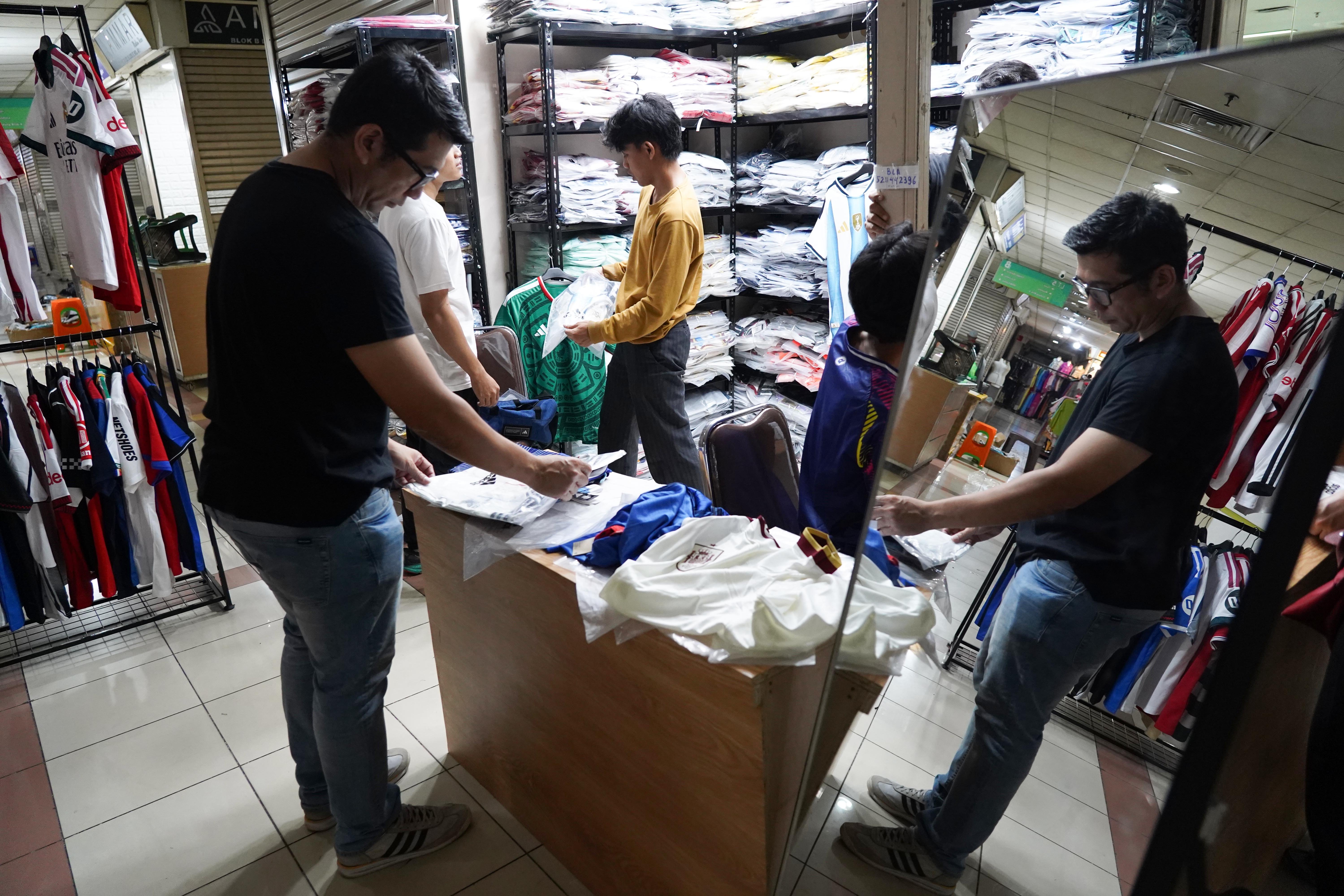 Calon pembeli melihat kaos sepak bola di Pasar Tanah Abang Blok B, Jakarta, Rabu (17/6/2026). Berdasarkan keterangan pedagang, jersi negara peserta Piala Dunia yang dijajakan mulai dari Rp 220 ribu-Rp 270 ribu itu diminati oleh penggemar sepak bola sehingga penjualannya meningkat.
