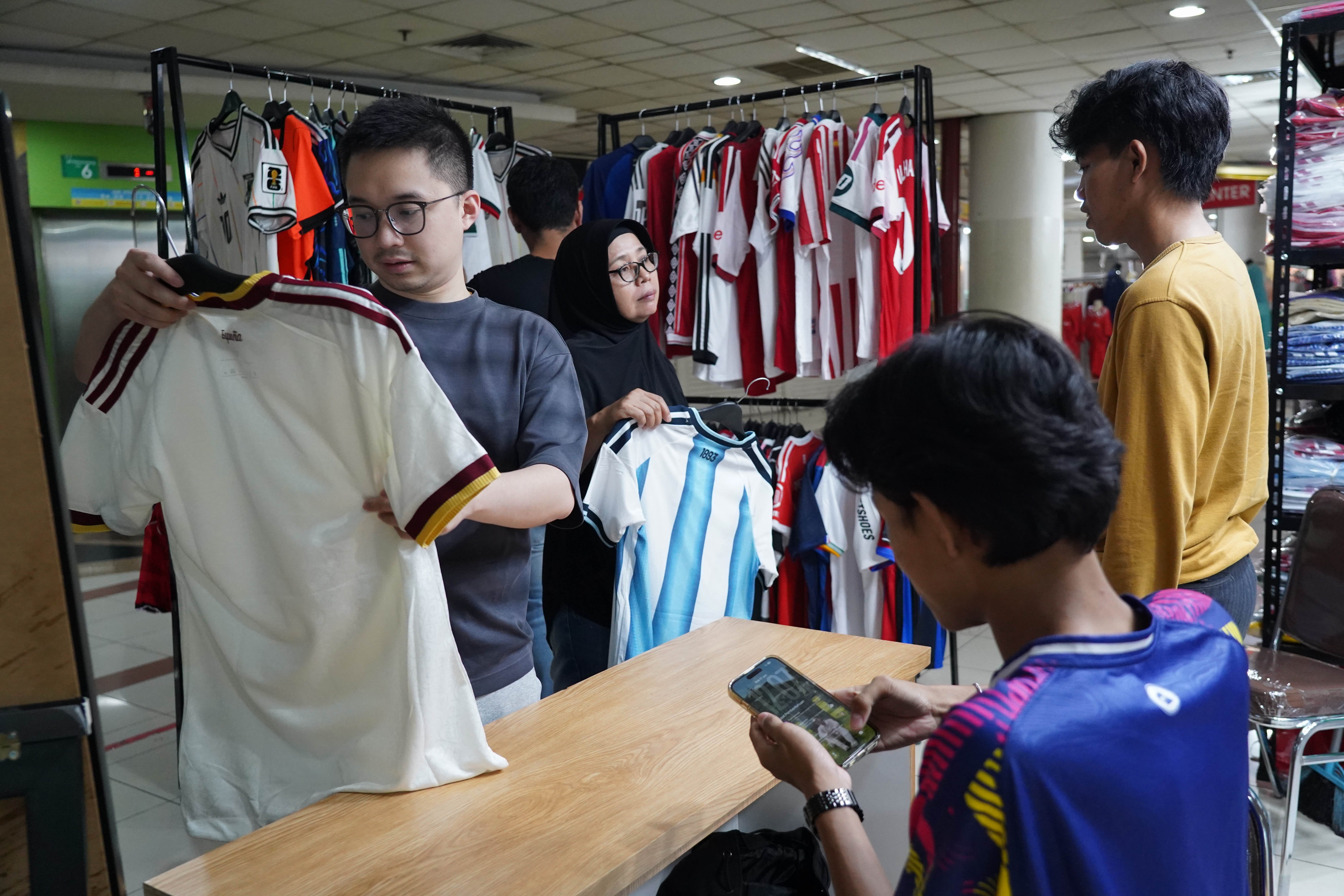 Calon pembeli melihat kaos sepak bola di Pasar Tanah Abang Blok B, Jakarta, Rabu (17/6/2026). Berdasarkan keterangan pedagang, jersi negara peserta Piala Dunia yang dijajakan mulai dari Rp 220 ribu-Rp 270 ribu itu diminati oleh penggemar sepak bola sehingga penjualannya meningkat.